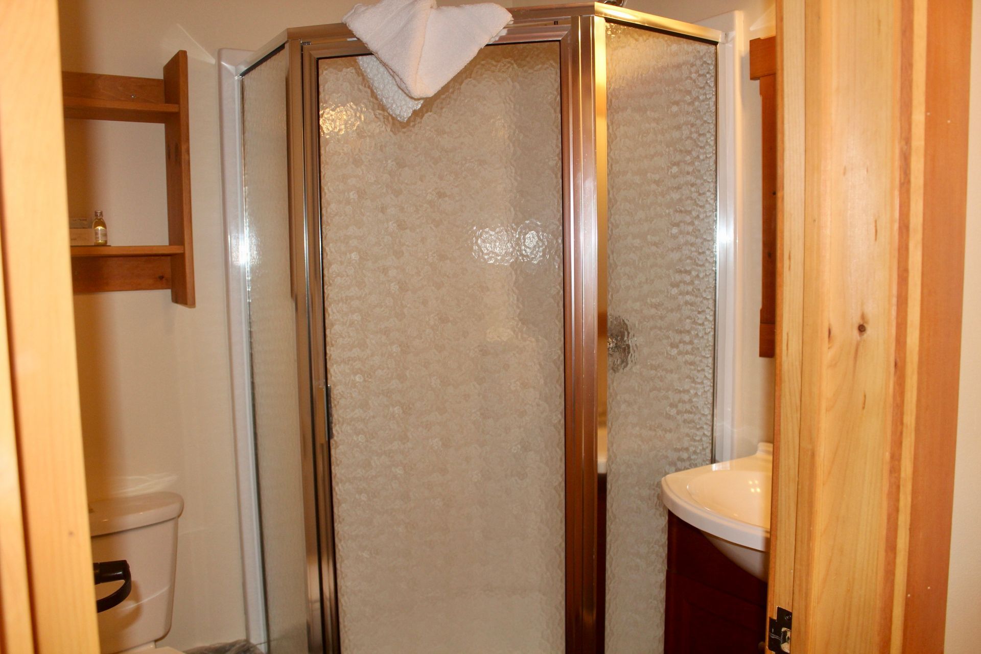 A bathroom with a toilet , sink and shower stall.