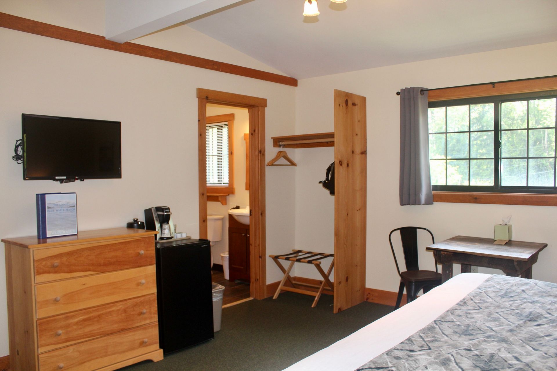 A hotel room with a king size bed and a flat screen tv