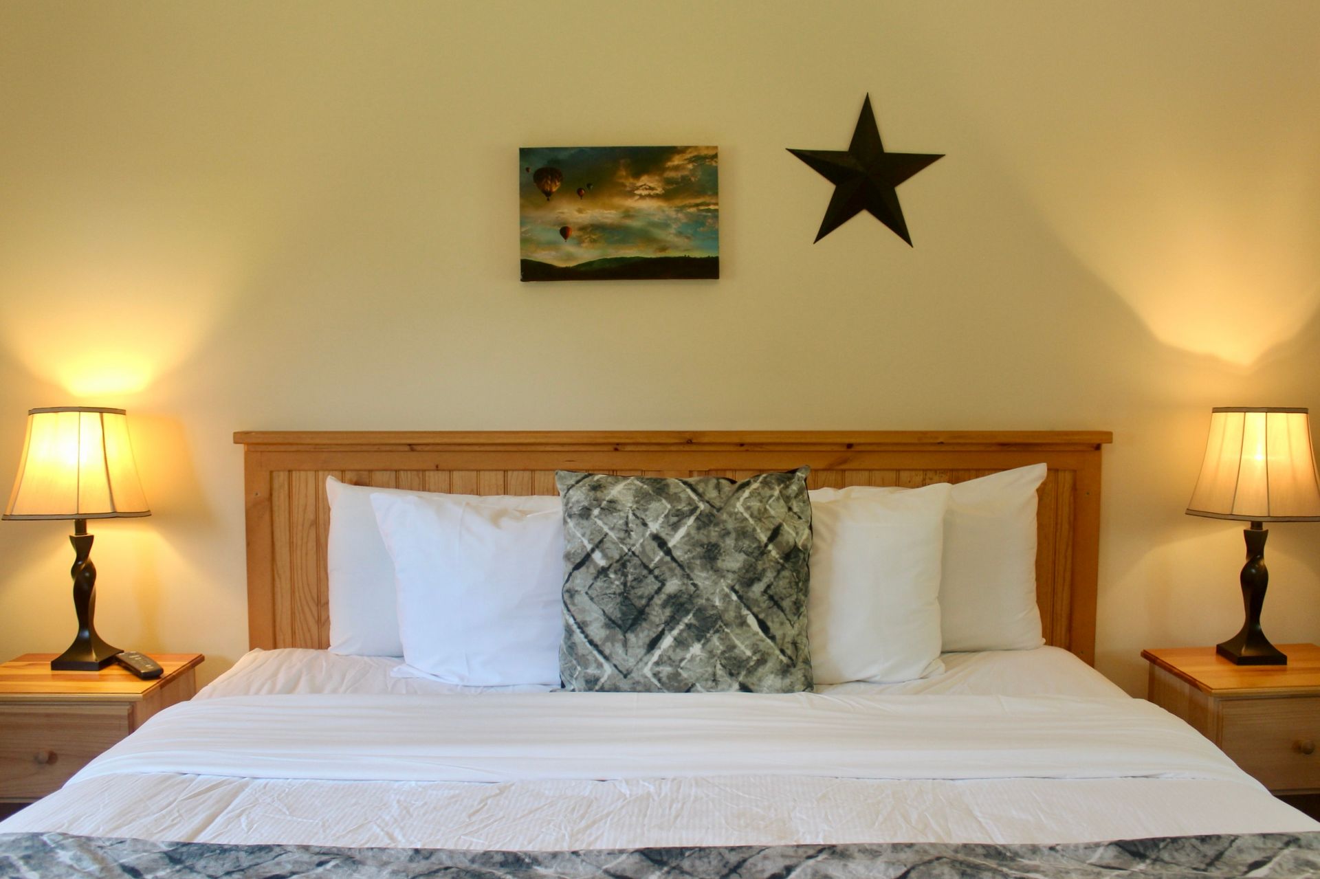 A bedroom with a bed , lamps and a star on the wall
