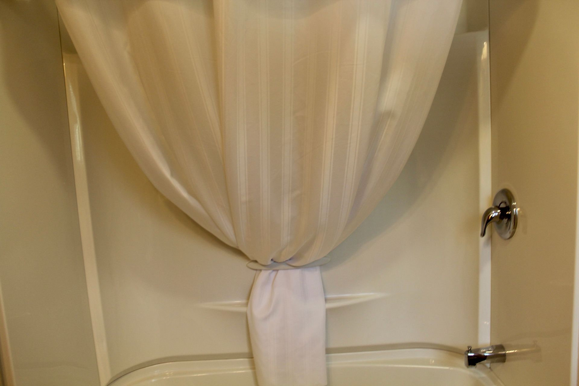 A shower curtain is hanging over a bathtub in a bathroom.