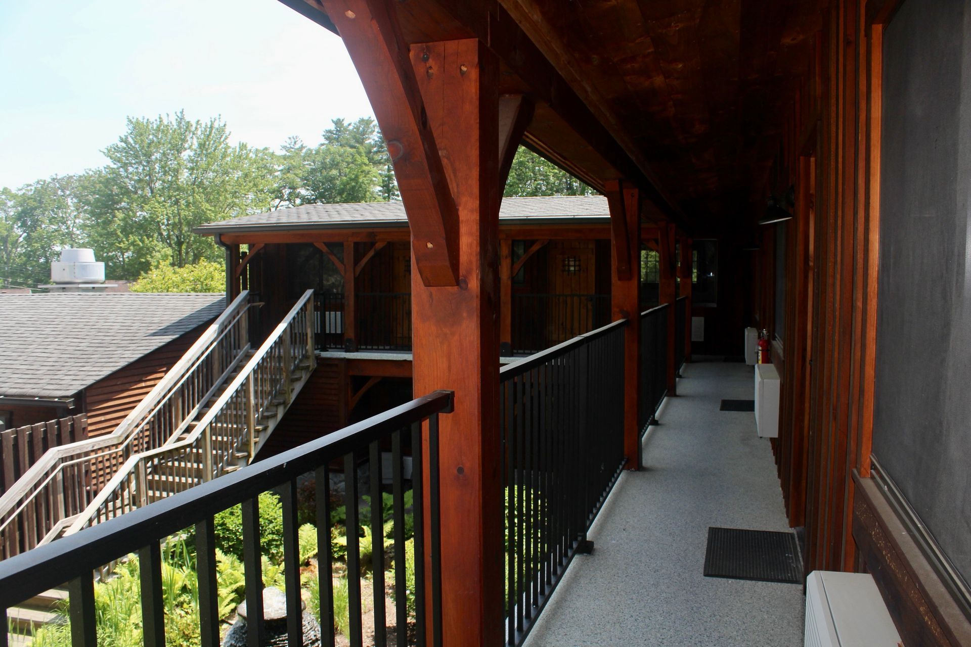 A long hallway between two buildings with a black railing