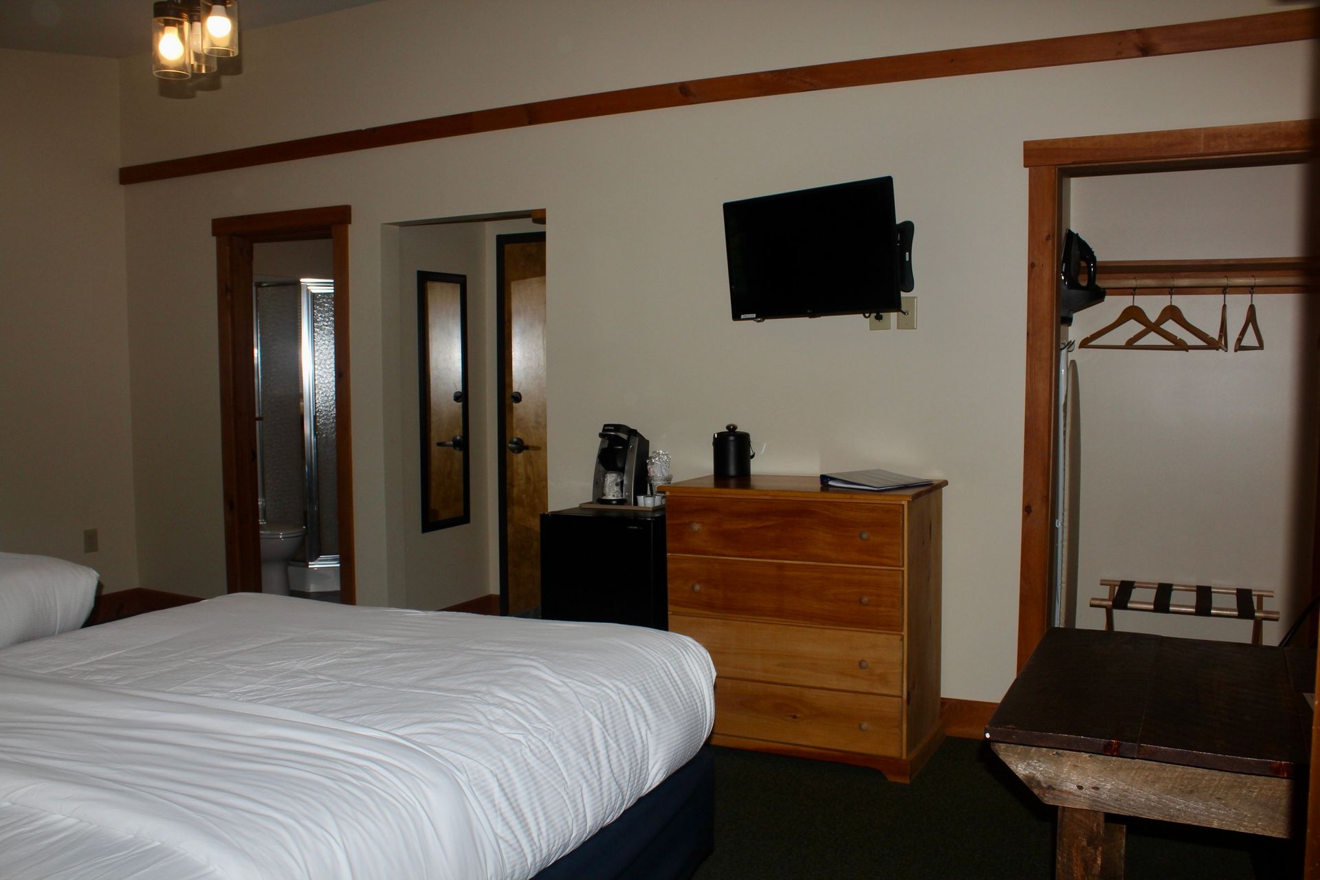 A hotel room with a king size bed and a flat screen tv