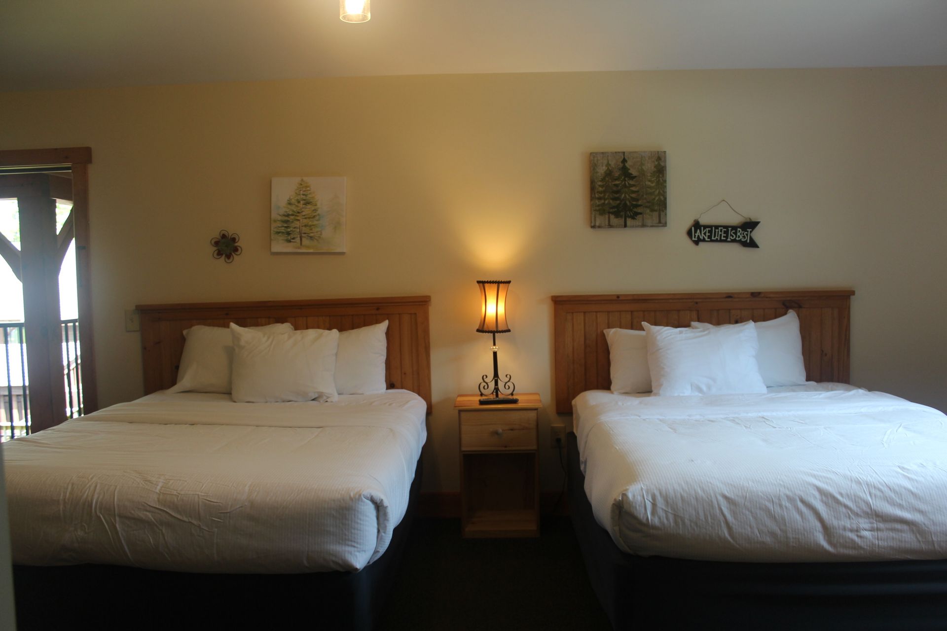 A hotel room with two beds and a nightstand.