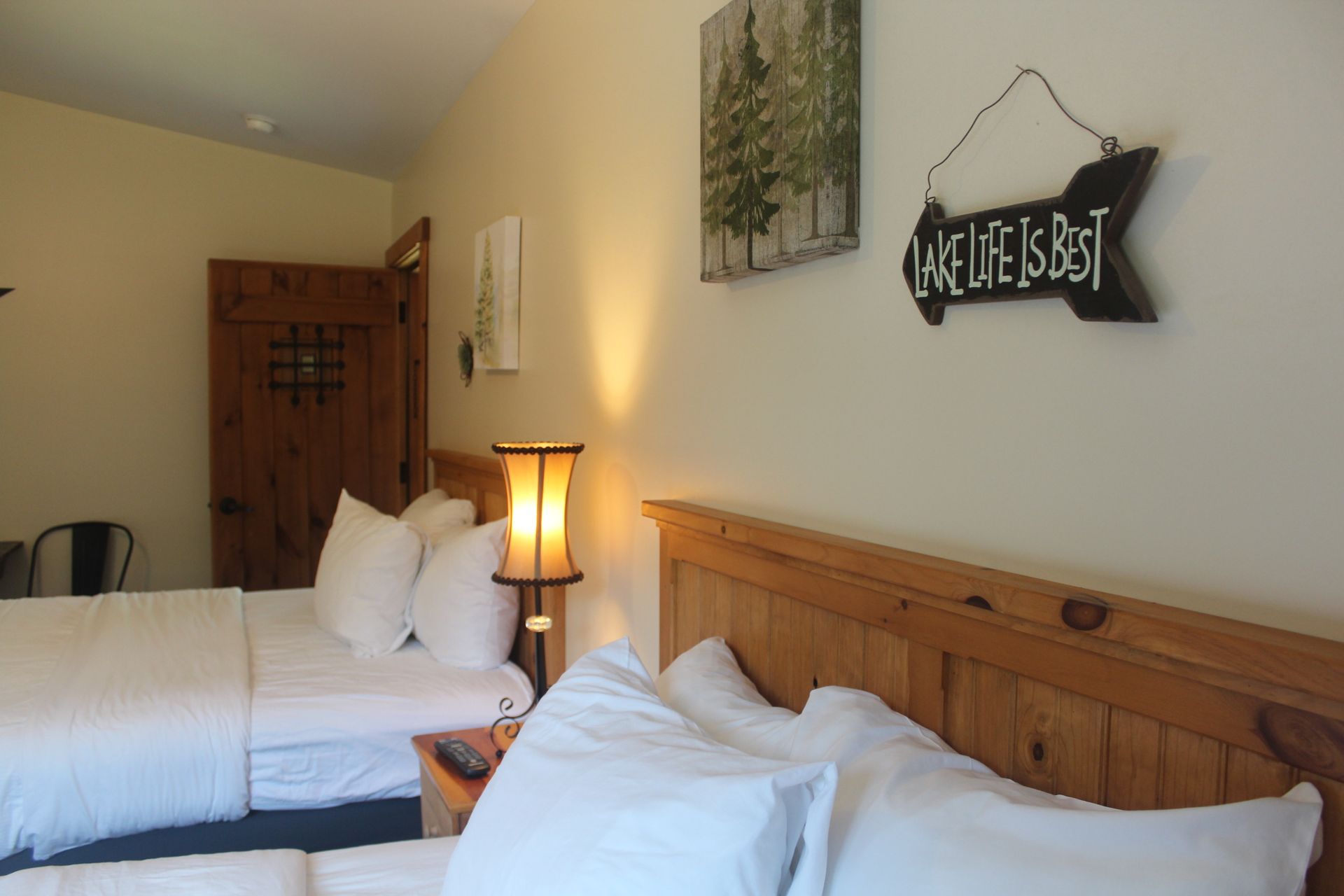 A hotel room with two beds and a sign that says lake life is best