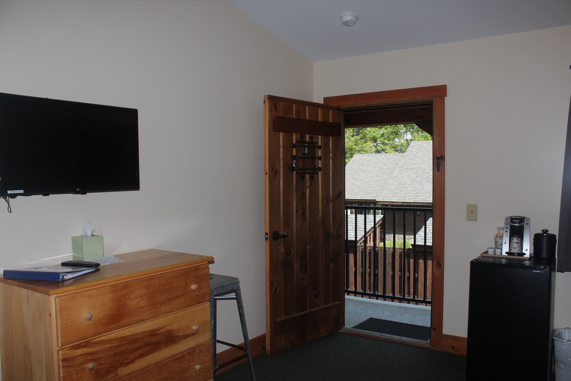 A room with a dresser and a flat screen tv