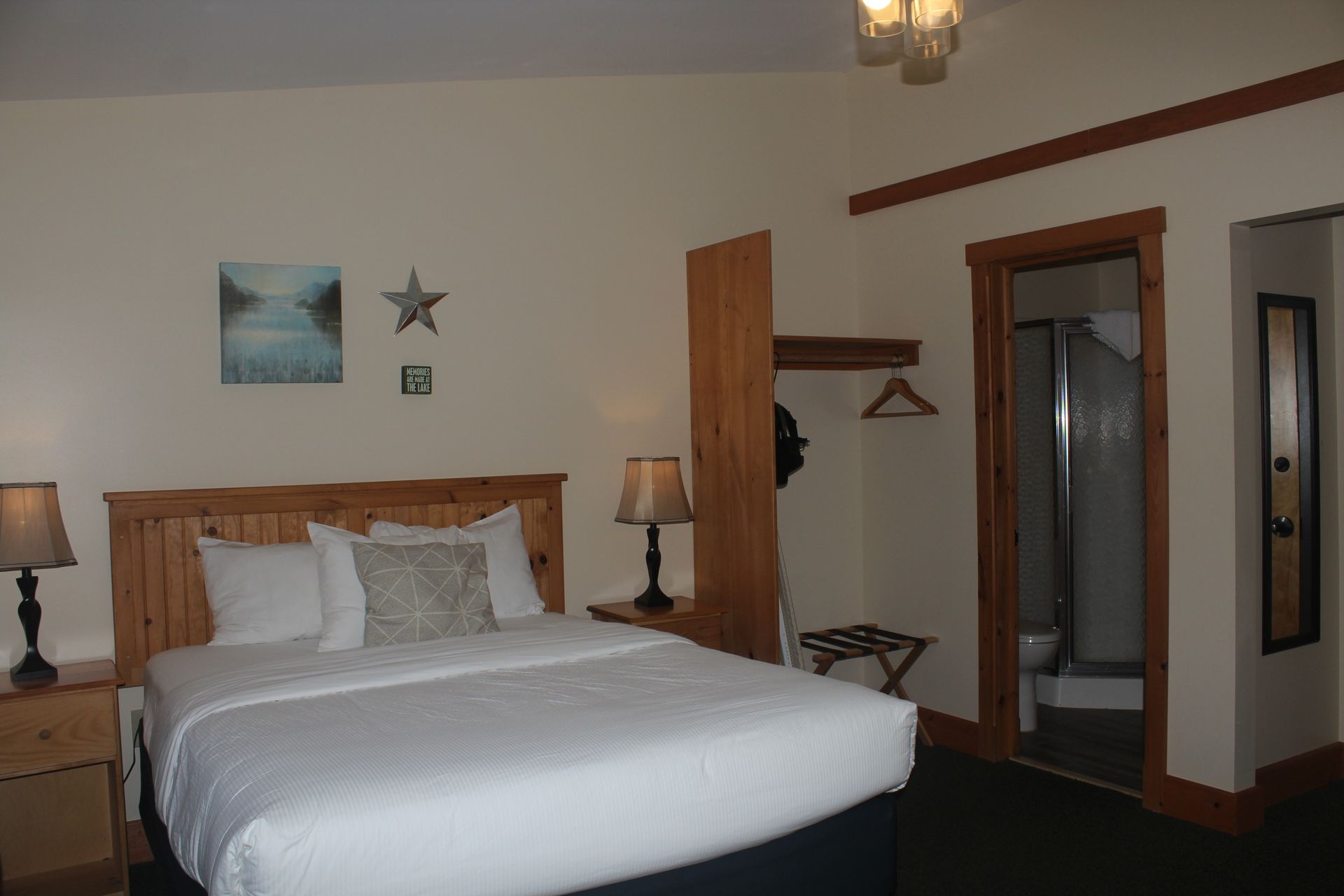 A hotel room with a king size bed and two lamps