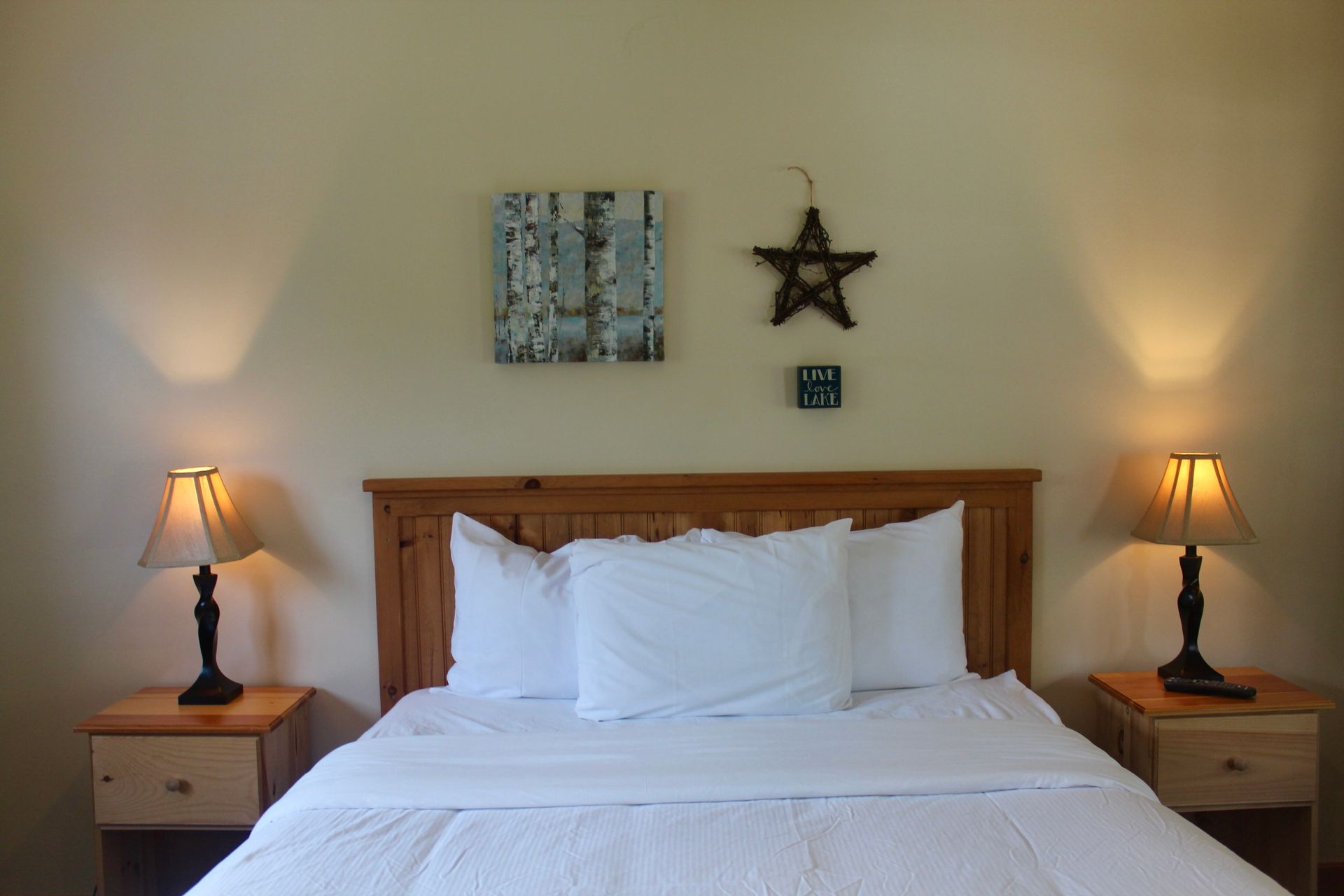 A bedroom with a bed lamps and a star on the wall
