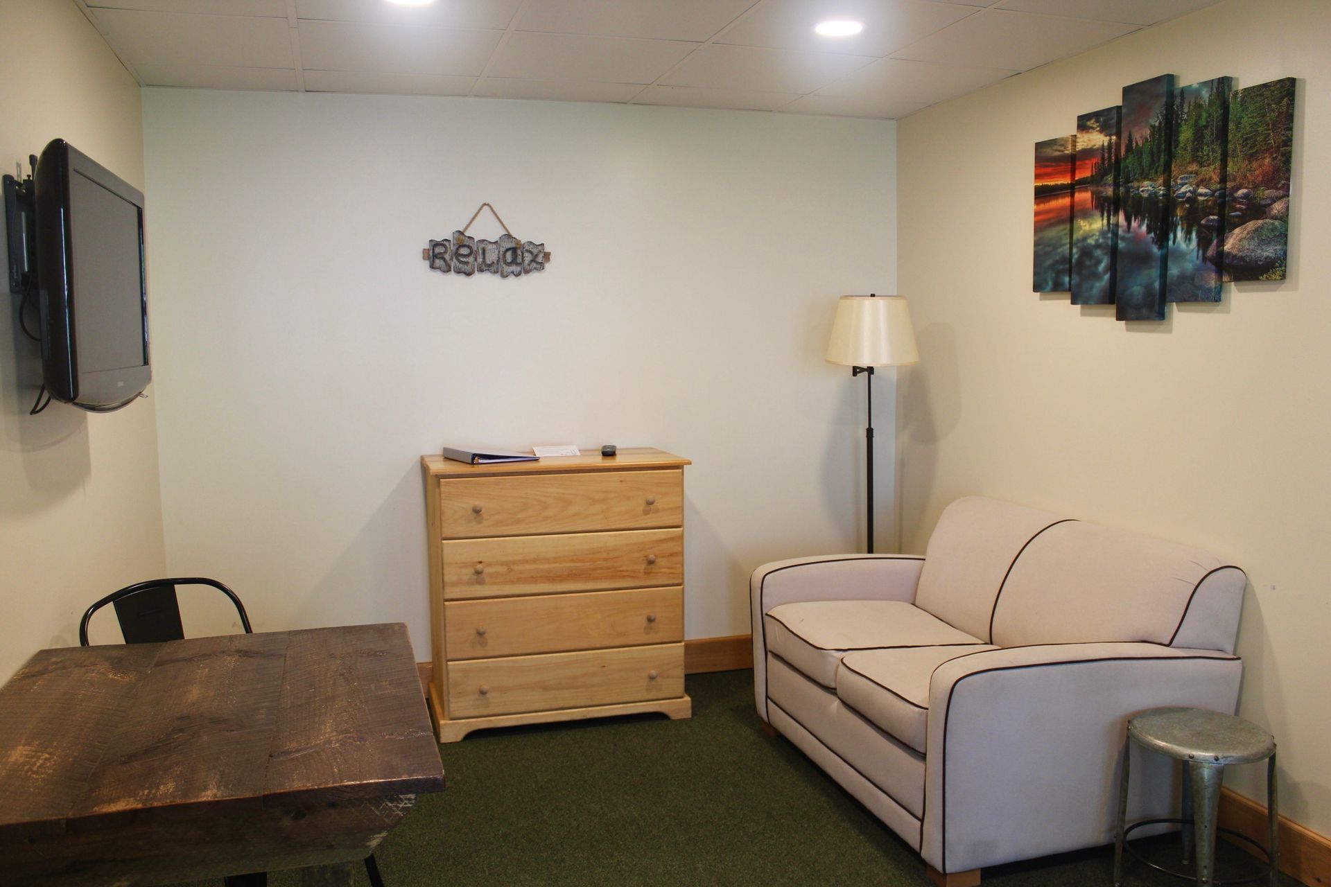 A living room with a couch , dresser , table and television.