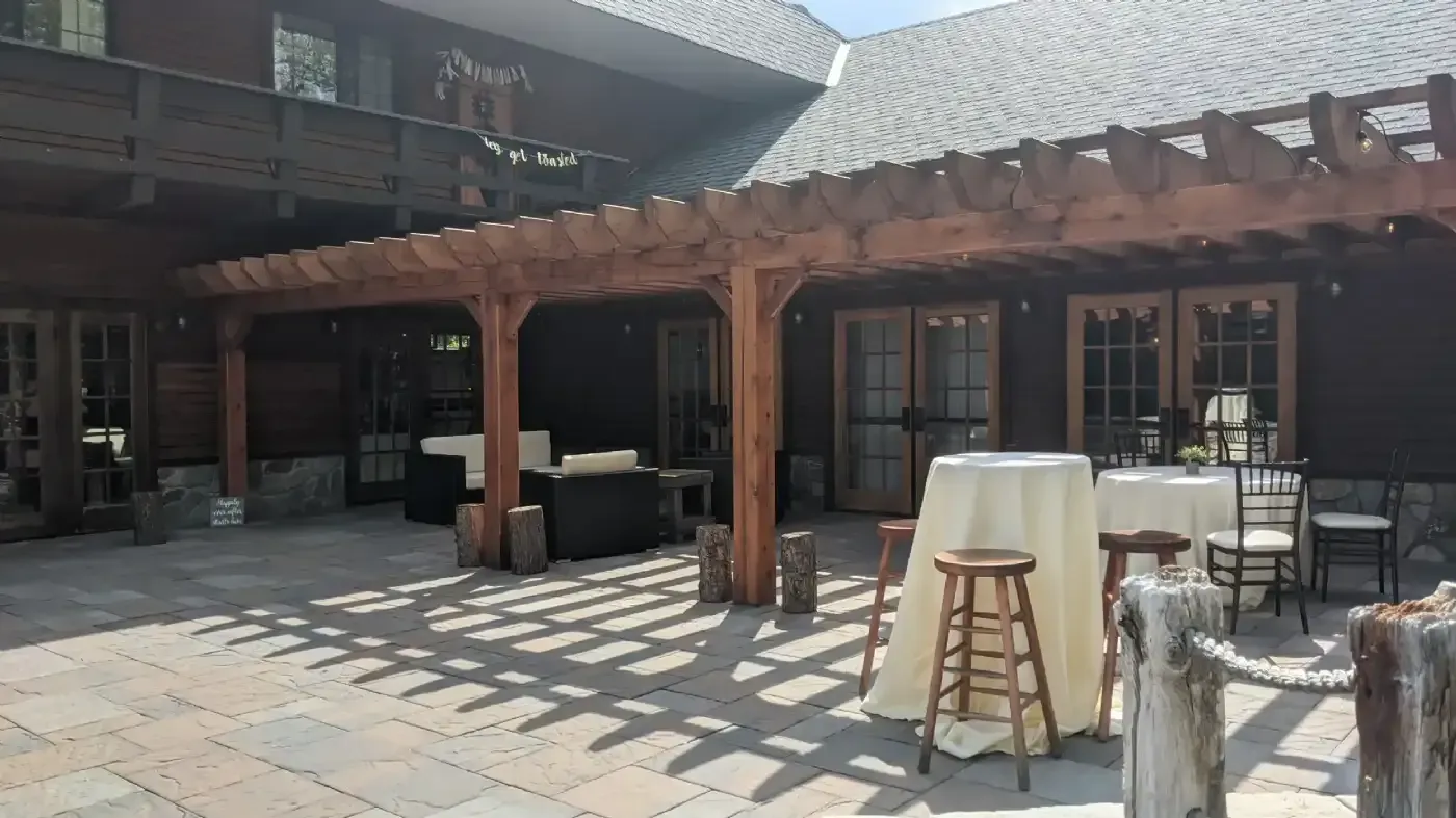 A patio with tables and chairs under a pergola.