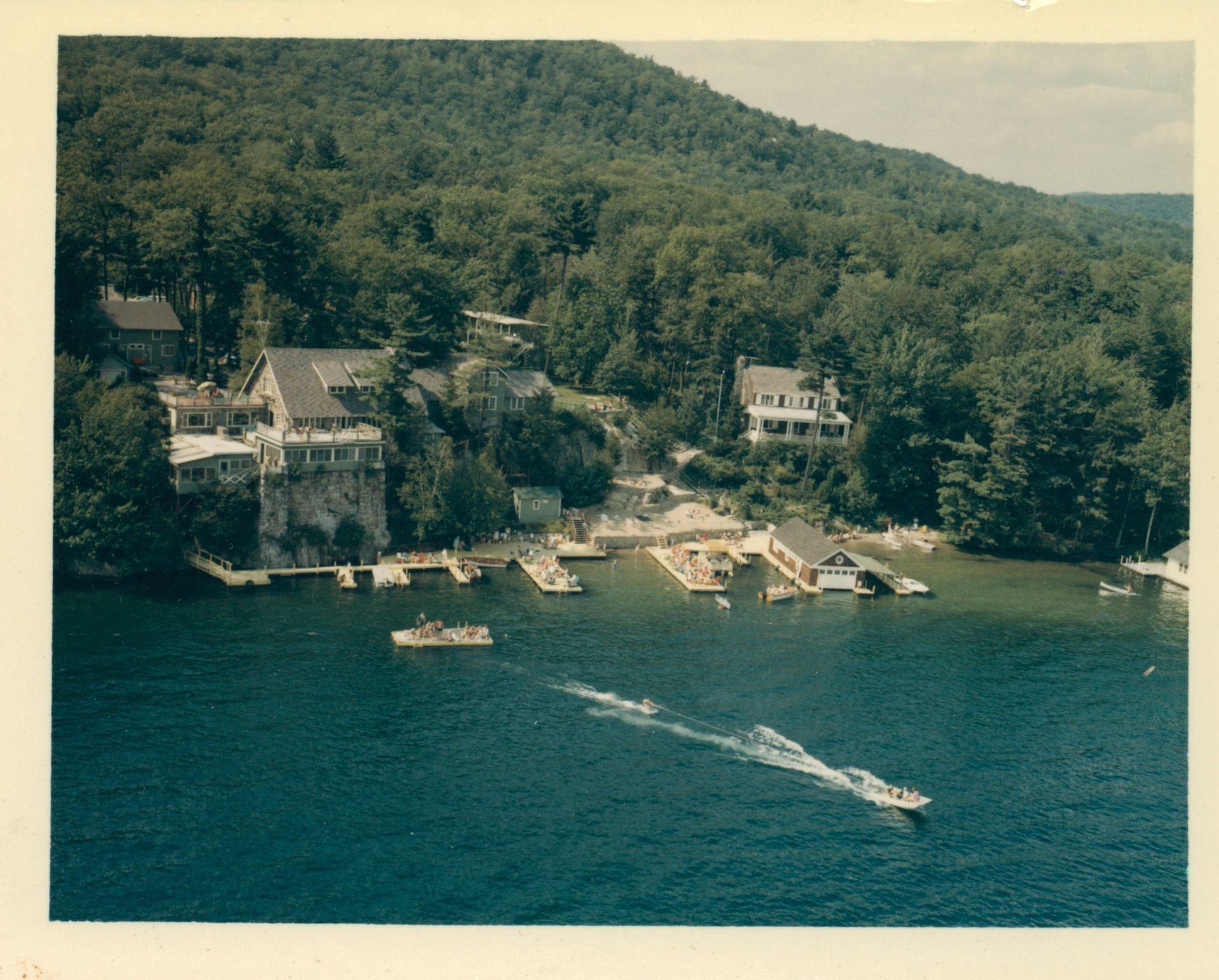 An aerial view of a lake with boats and houses in the background