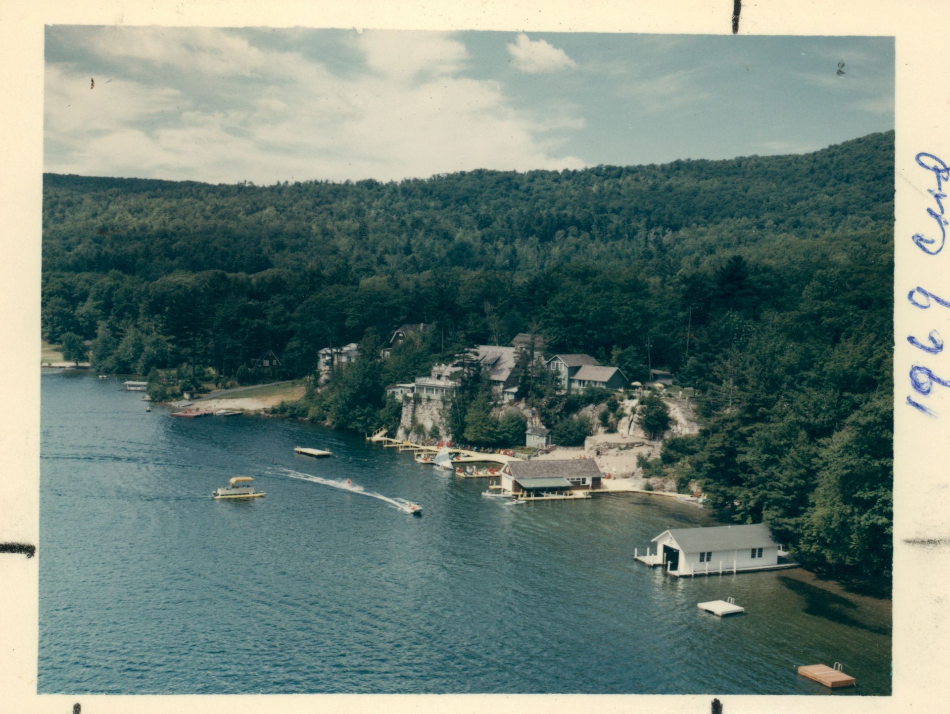 An aerial view of a lake with boats in it from 1969