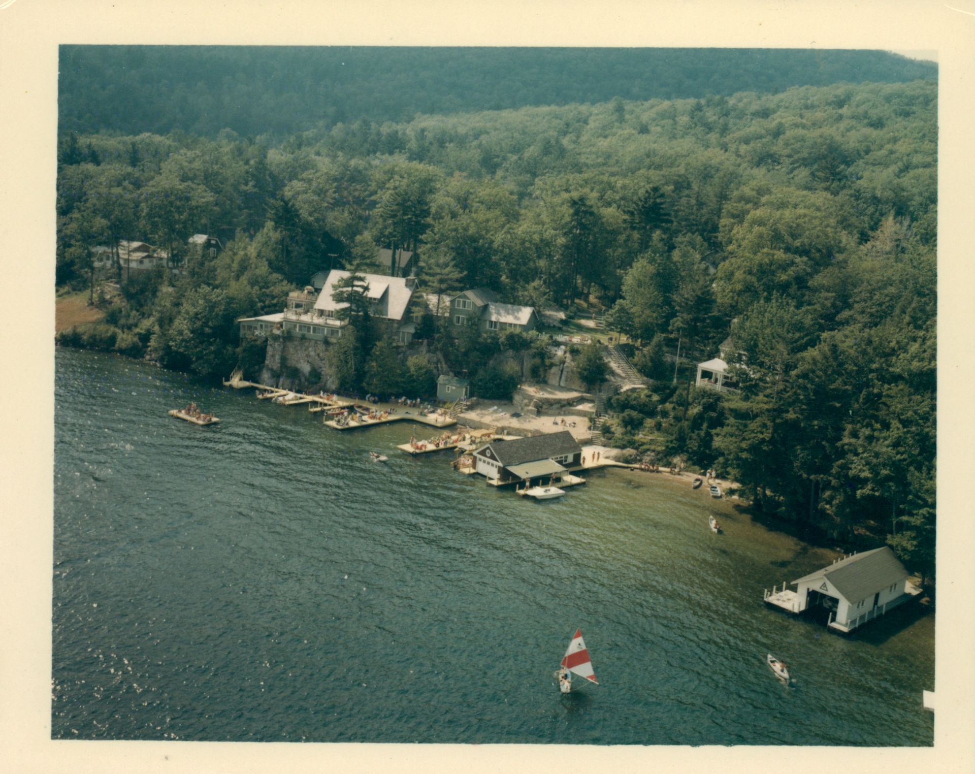 An aerial view of Blue Water Manor with a sailboat in the water