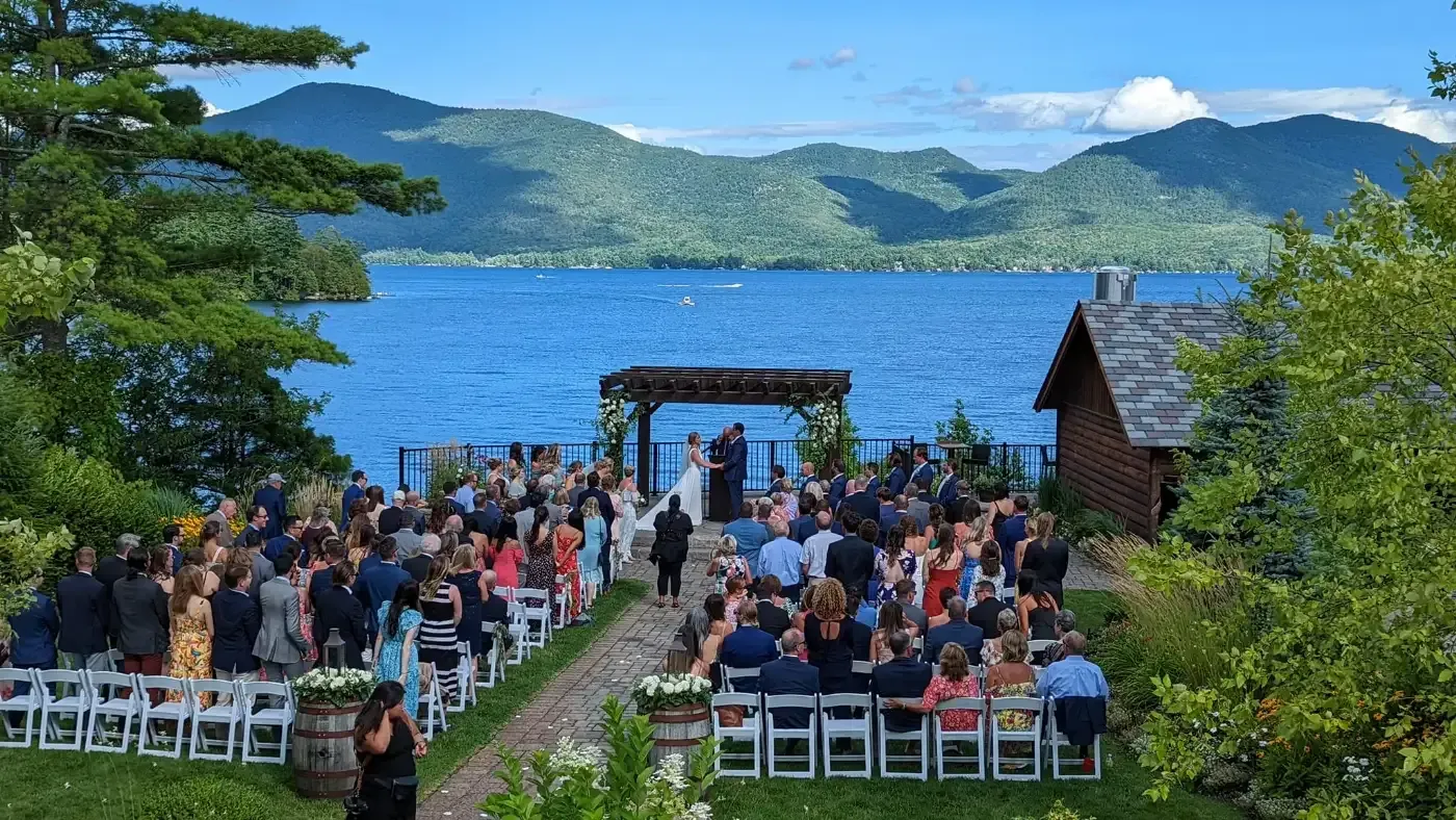 A large group of people are sitting in front of a lake.