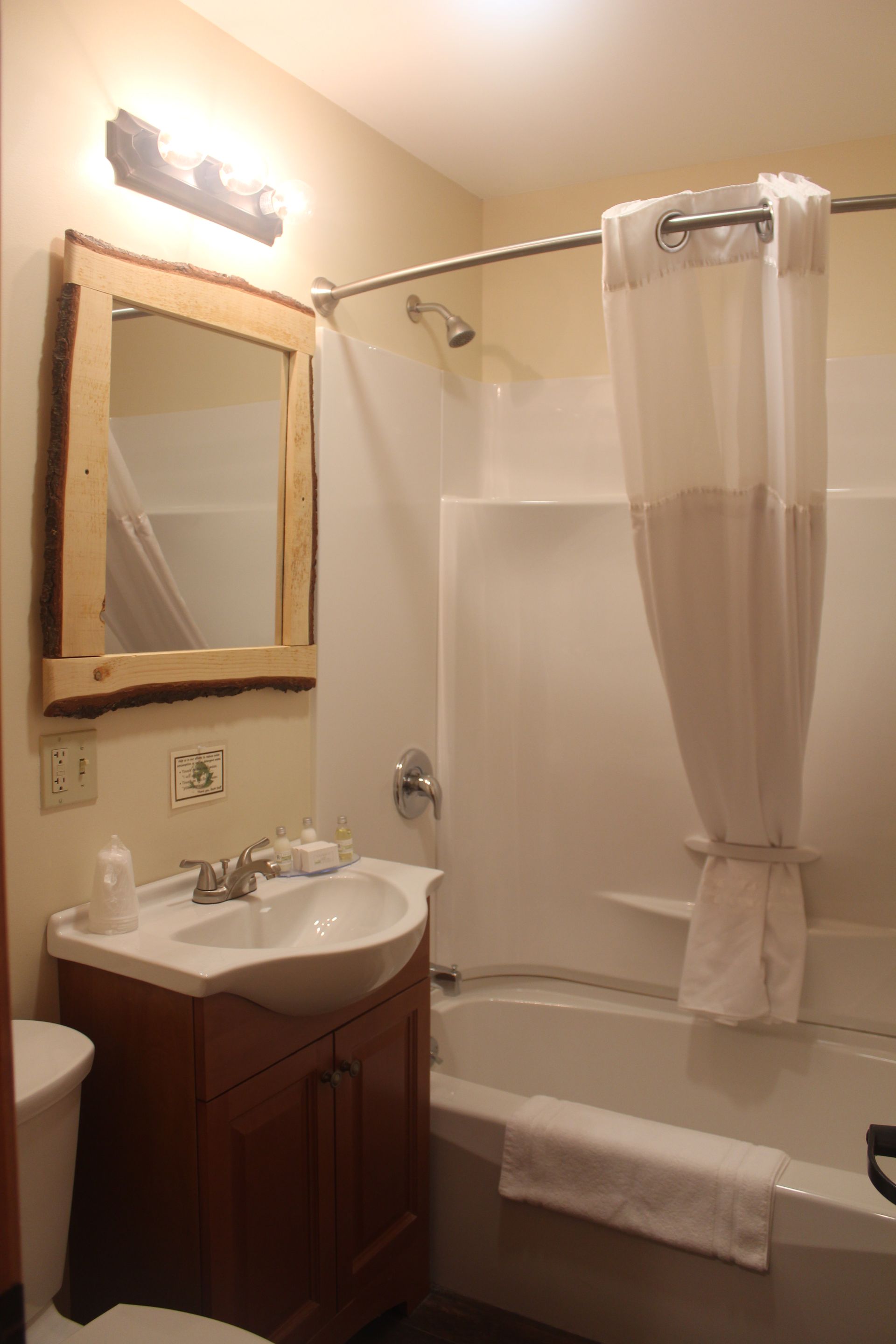 A bathroom with a sink , toilet , tub and mirror.