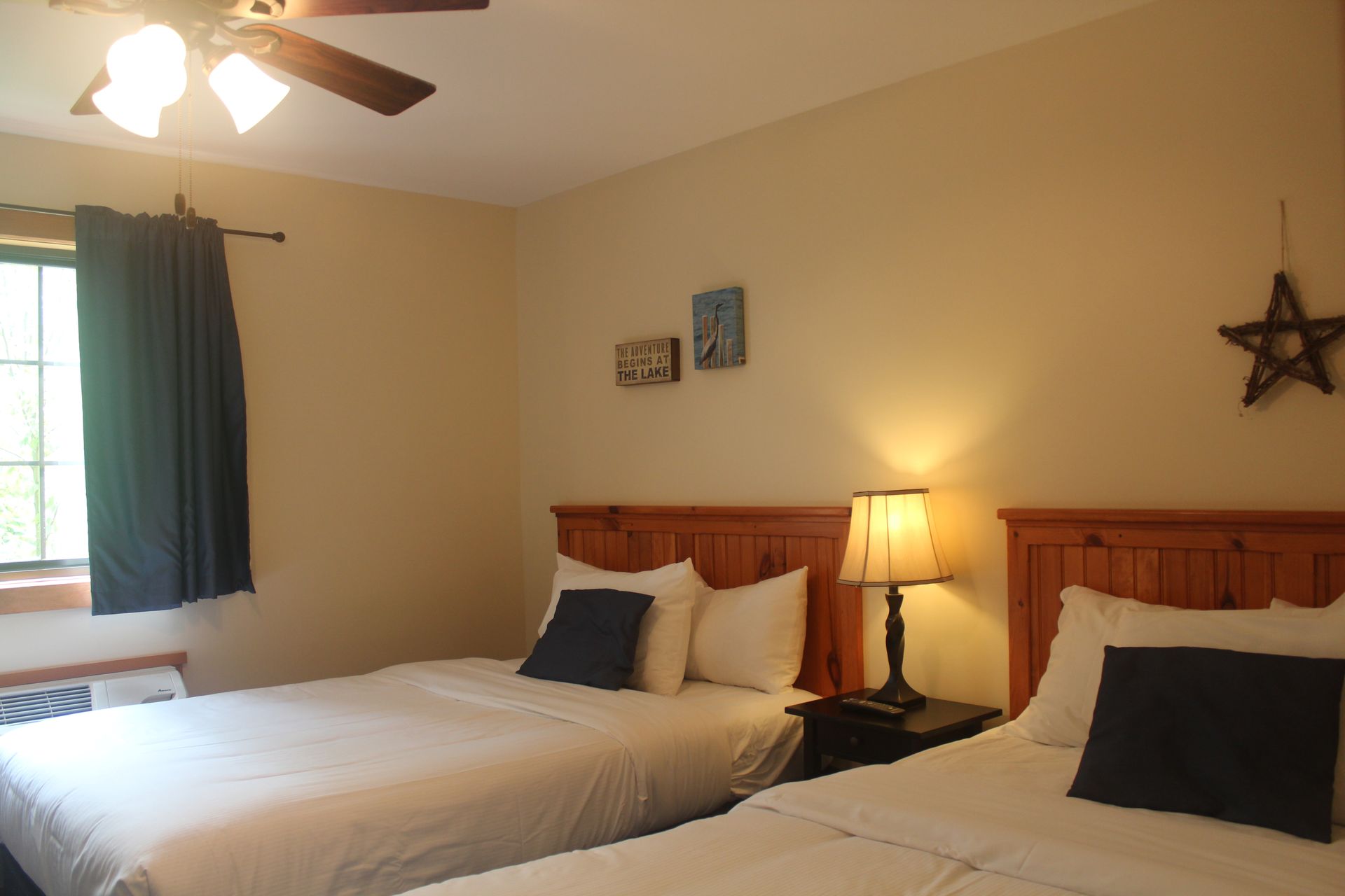 A hotel room with two beds and a ceiling fan