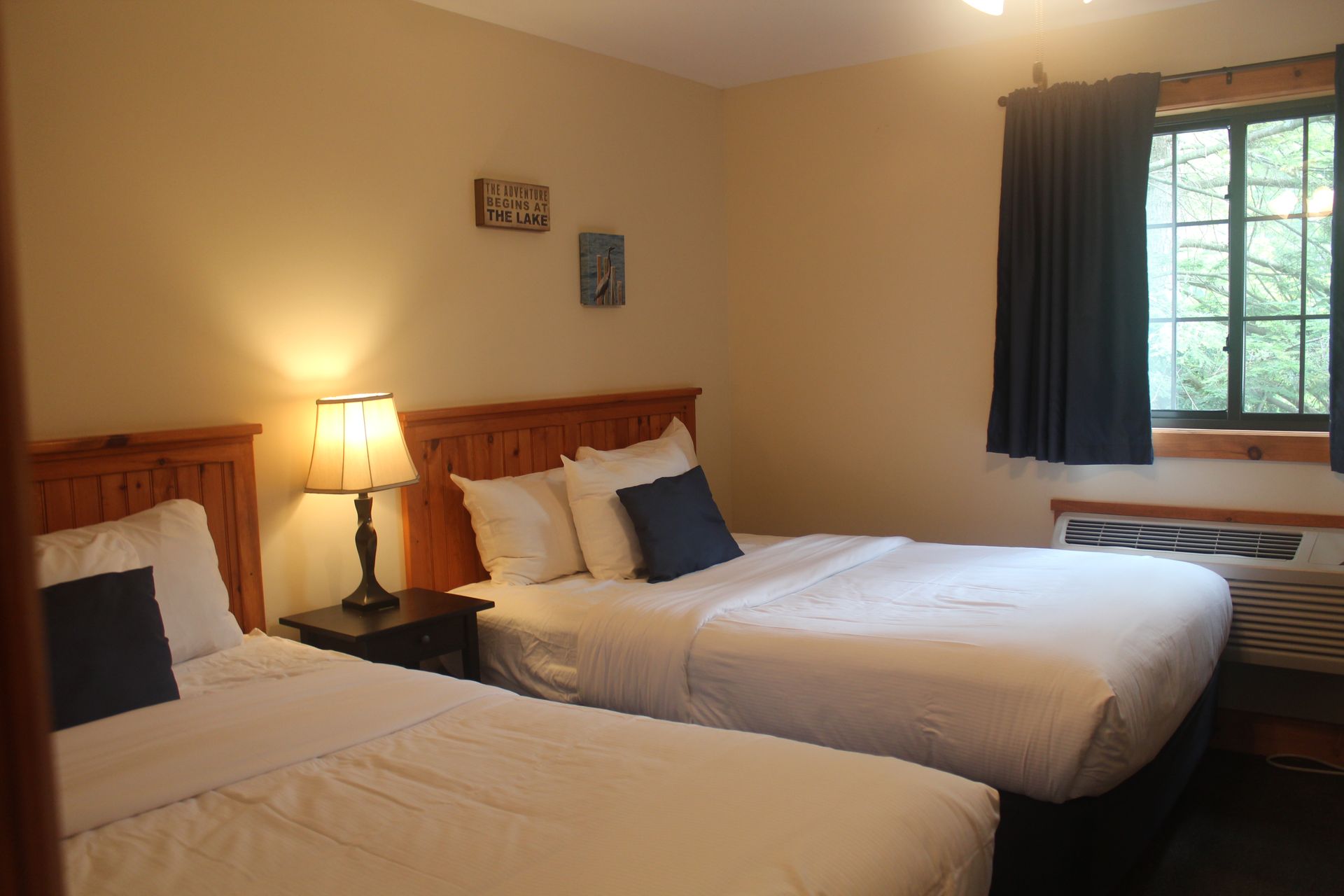 A hotel room with two beds and a window.
