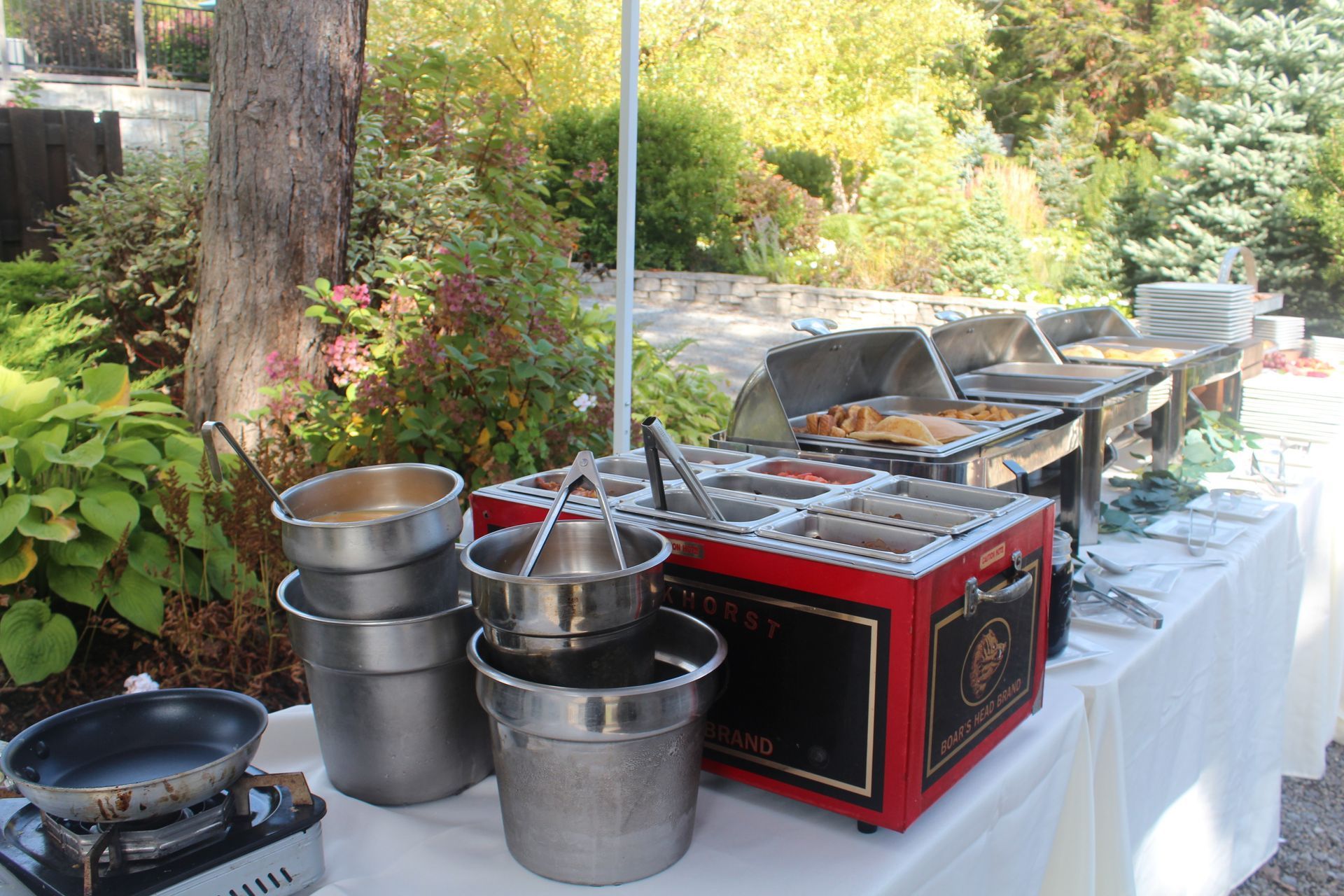A buffet table with a lot of pots and pans on it.