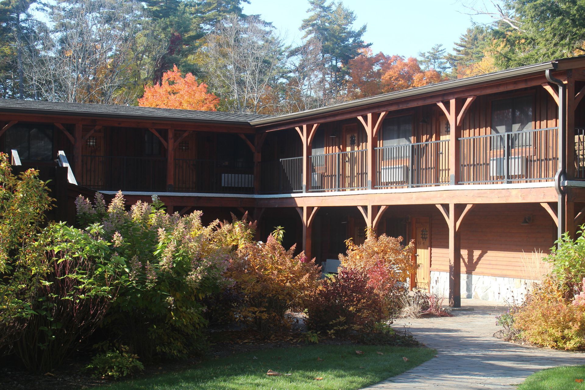 A large wooden building with a balcony and trees in the background