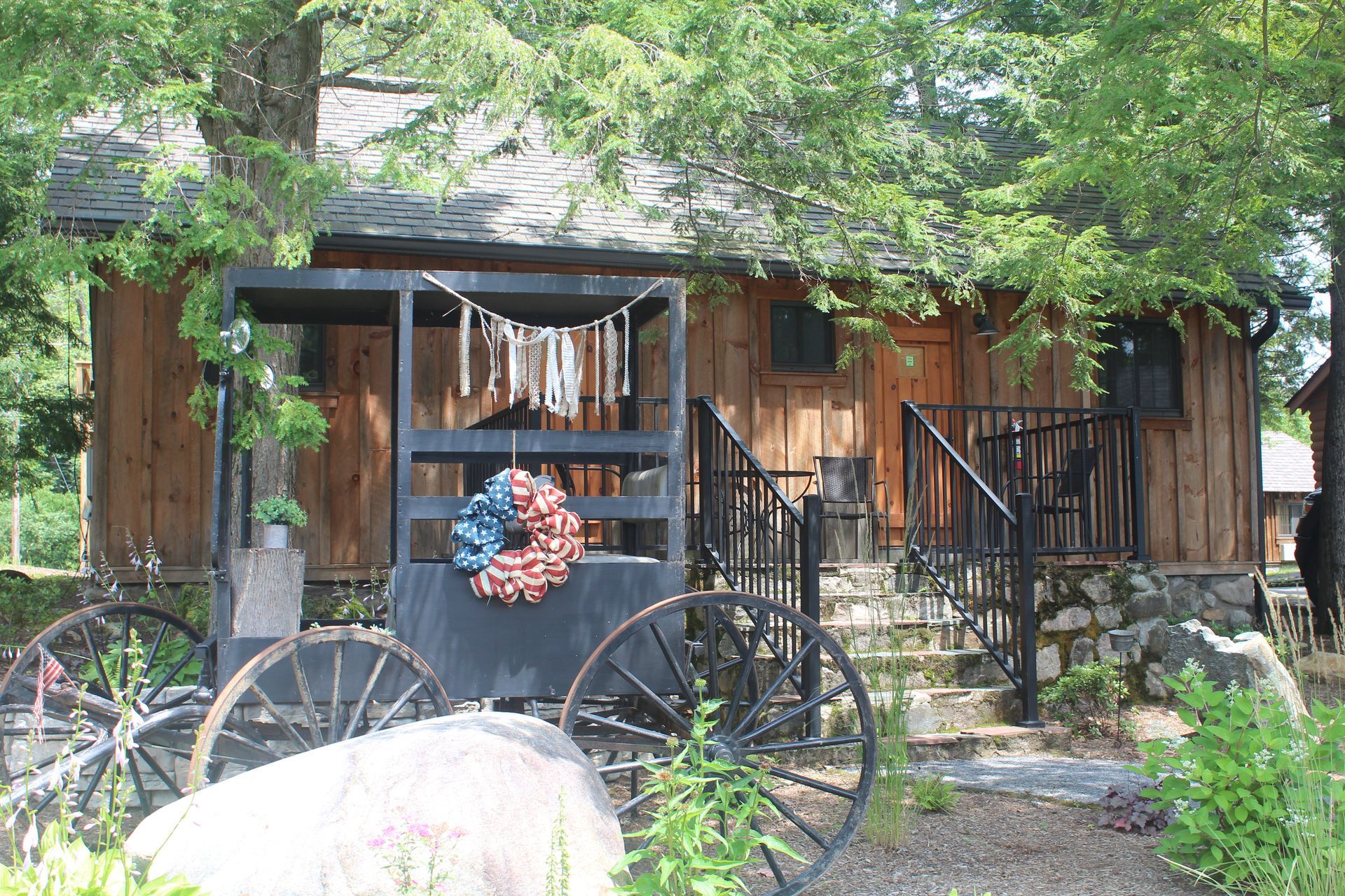 A horse drawn carriage is parked in front of a wooden house.