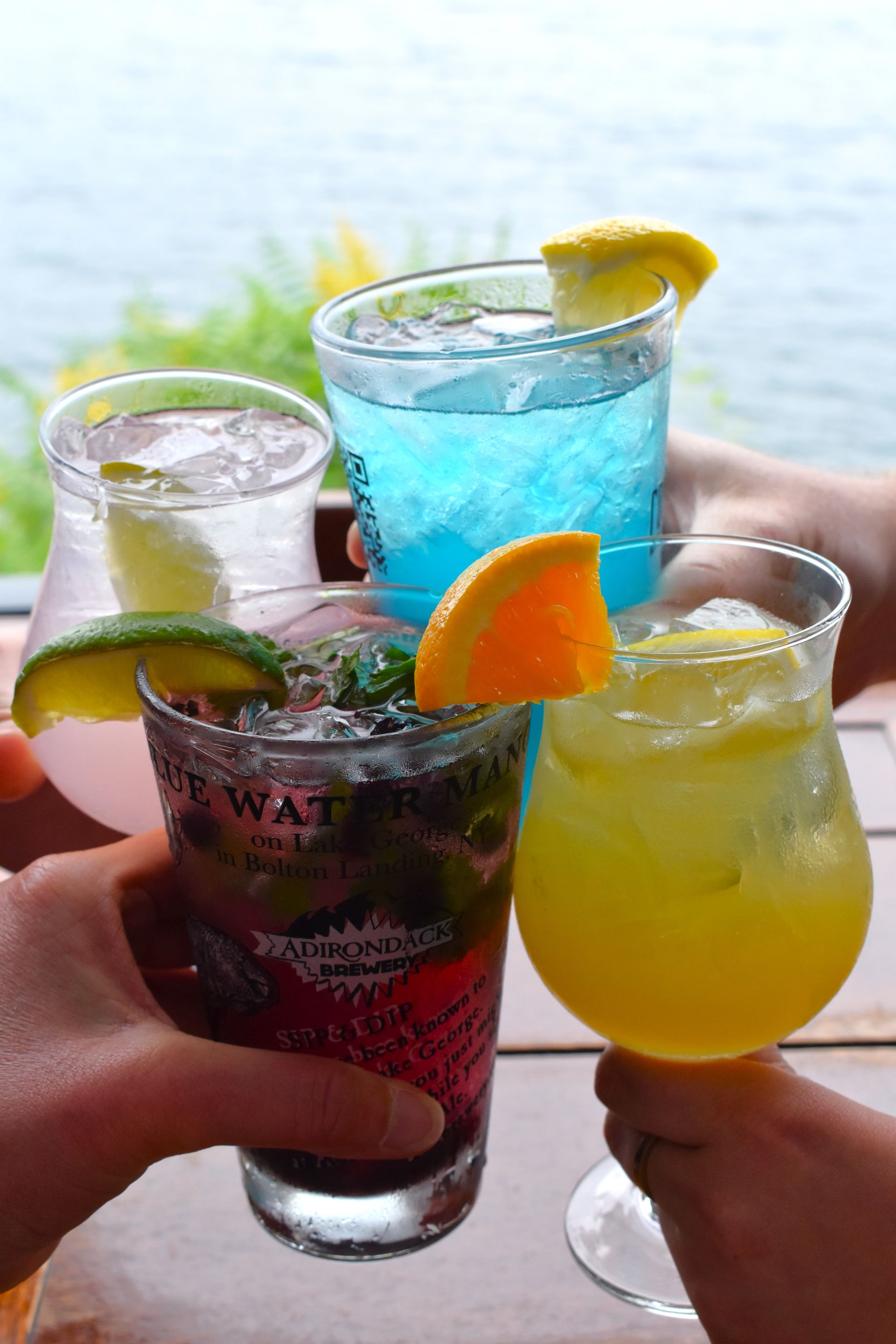 A group of people are toasting with drinks on a table.