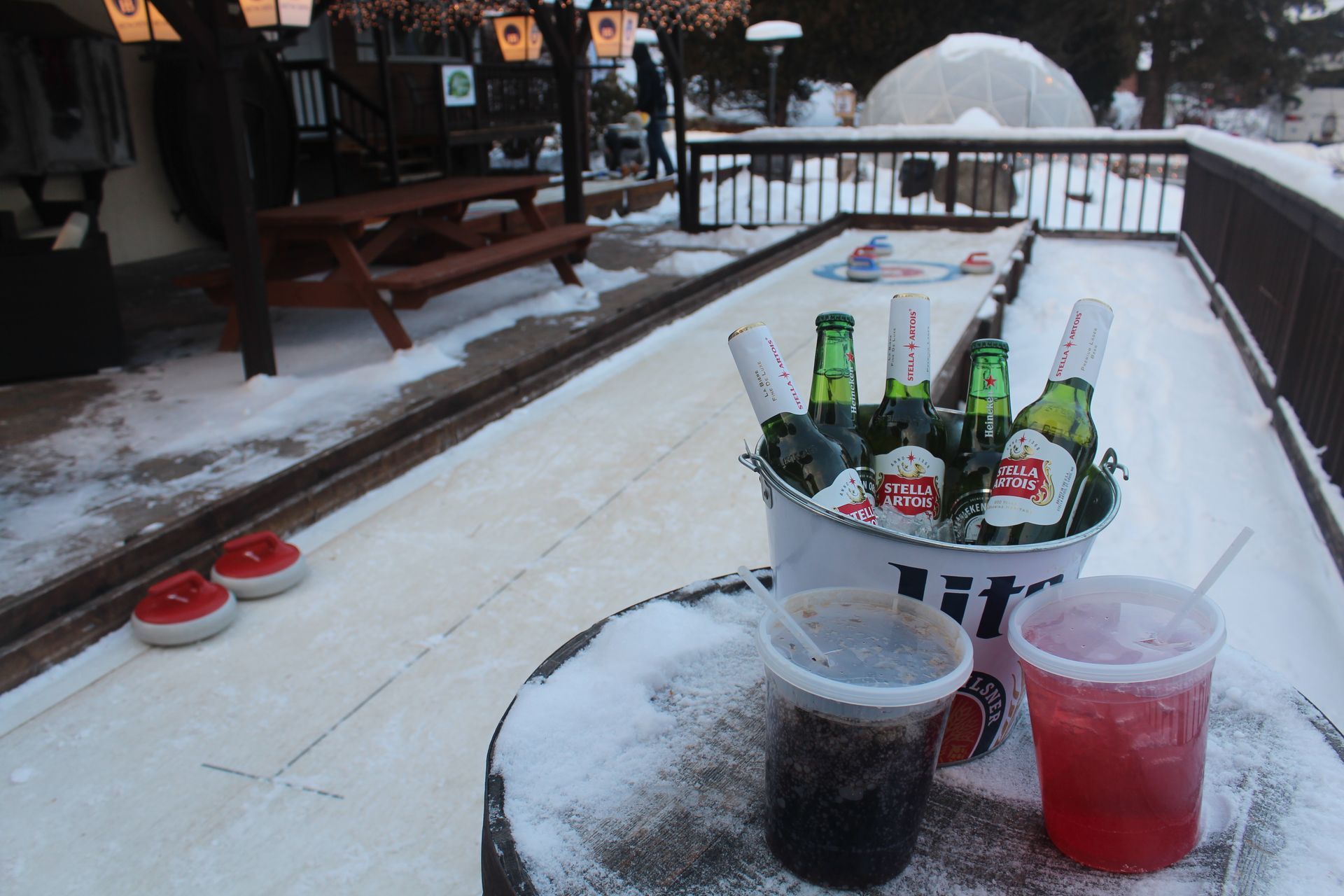 A bucket of beer sits on a snowy table