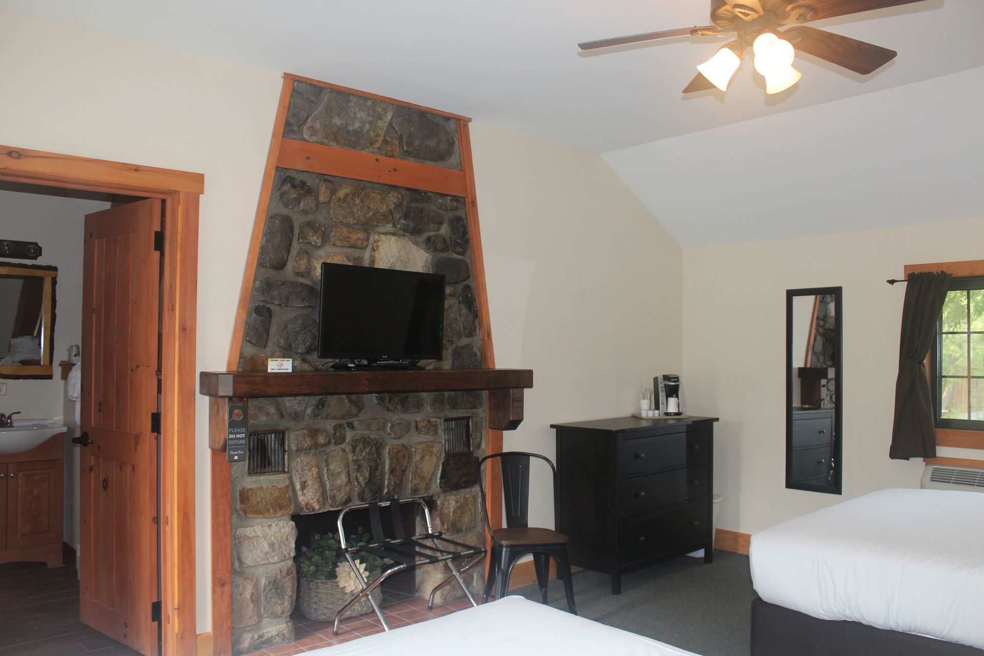 A bedroom with two beds a fireplace and a flat screen tv