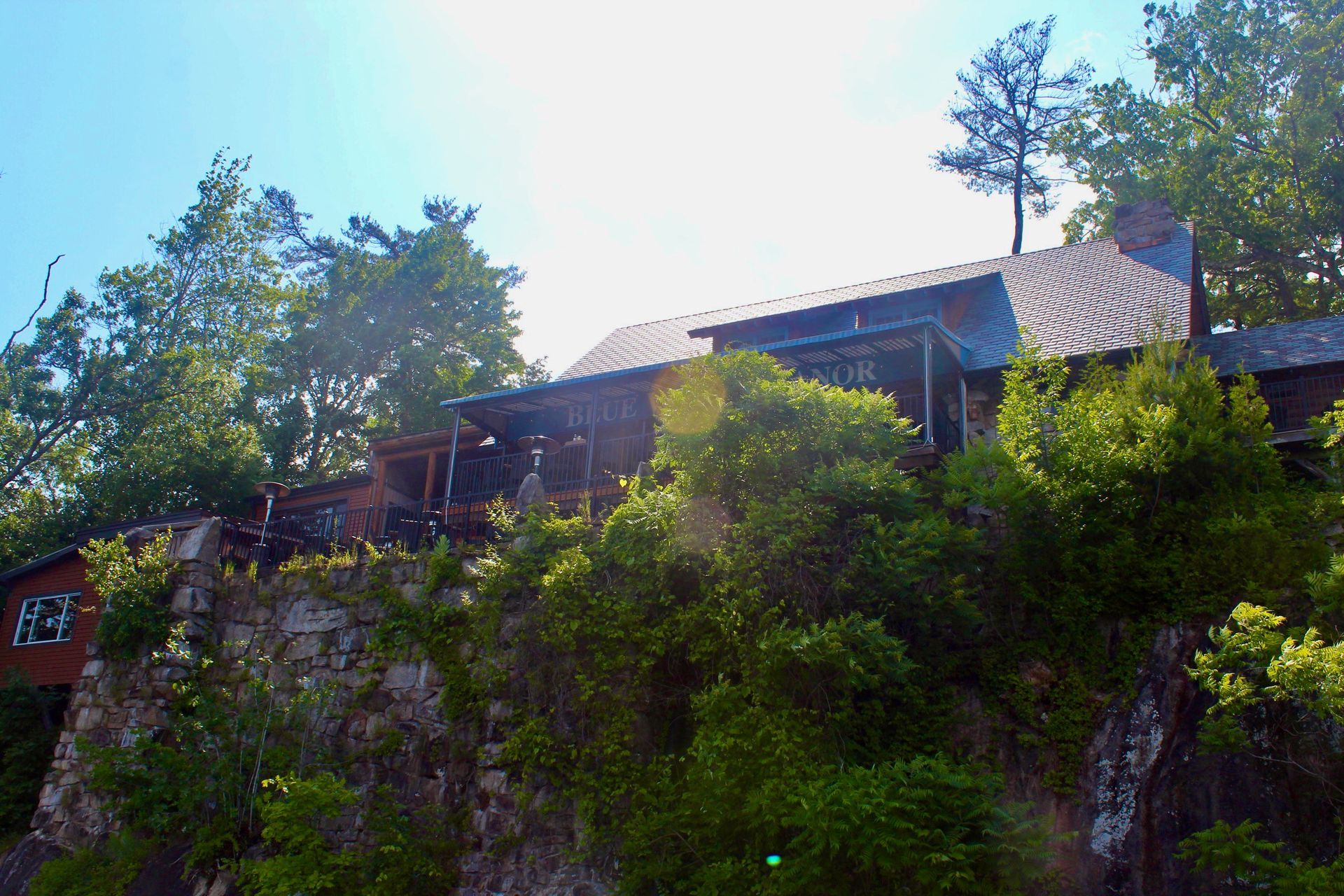 A house sits on top of a hill surrounded by trees