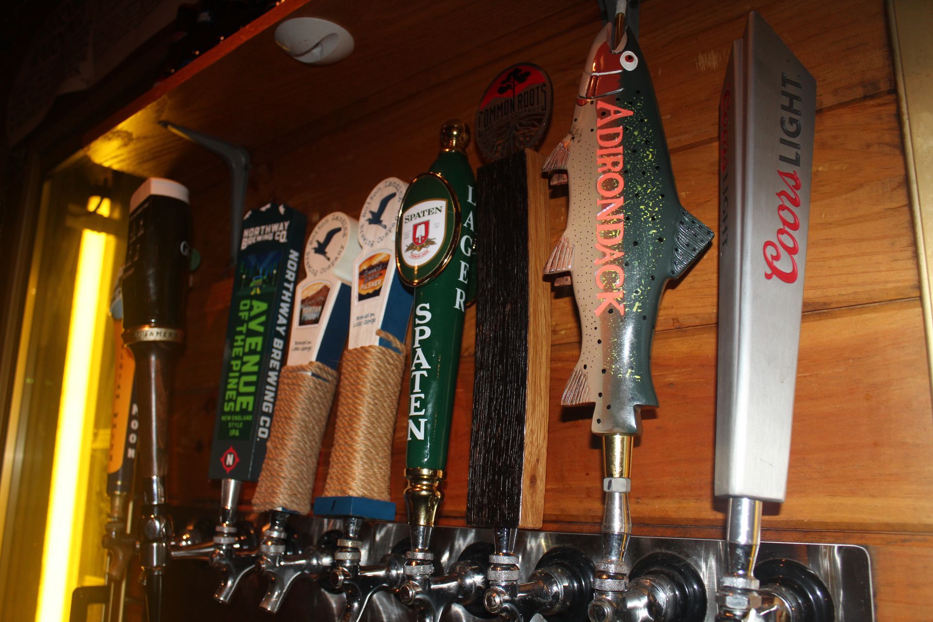 A row of beer taps with one that says ' coors light ' on it