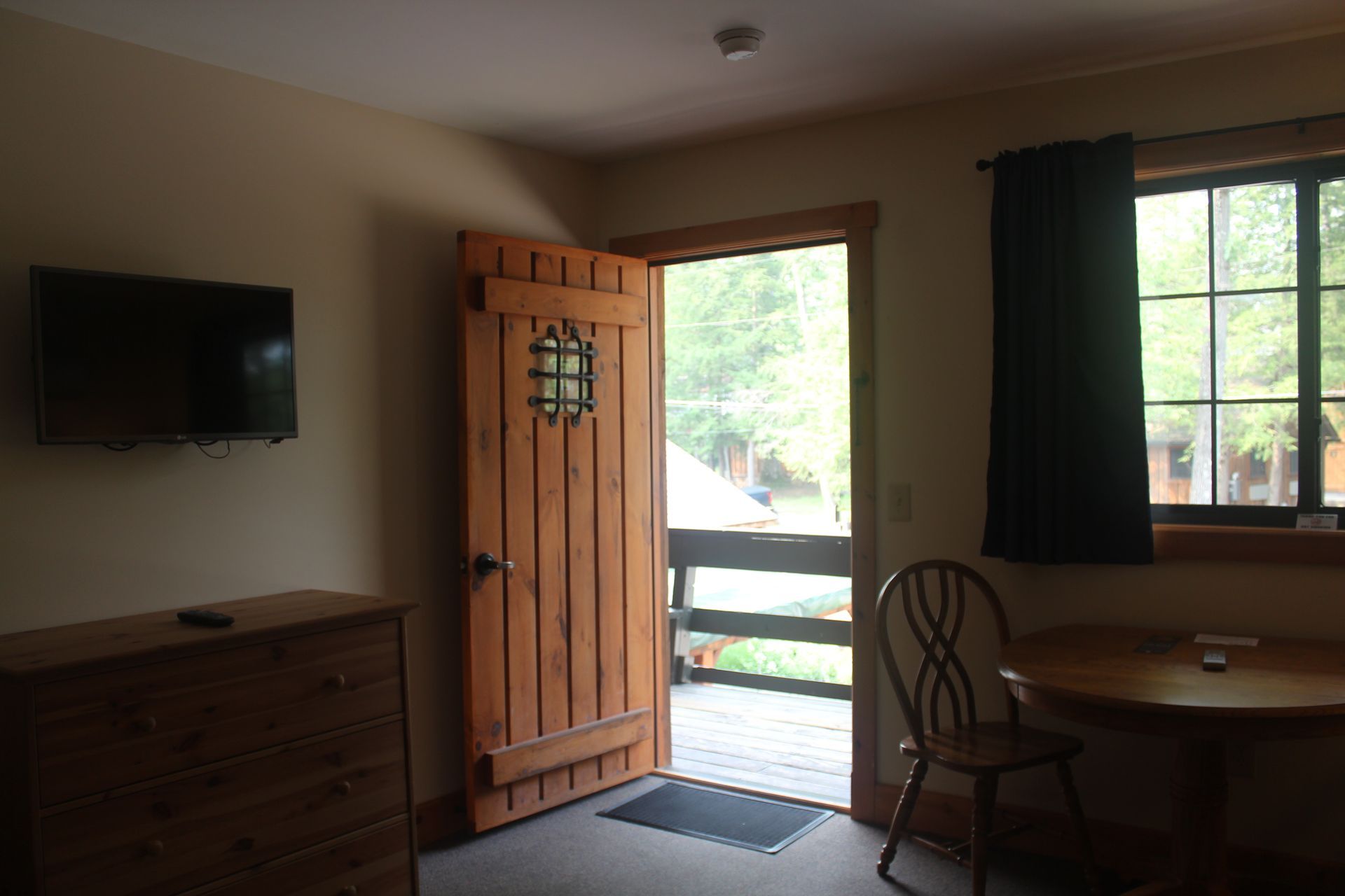 A room with a wooden door and a flat screen tv