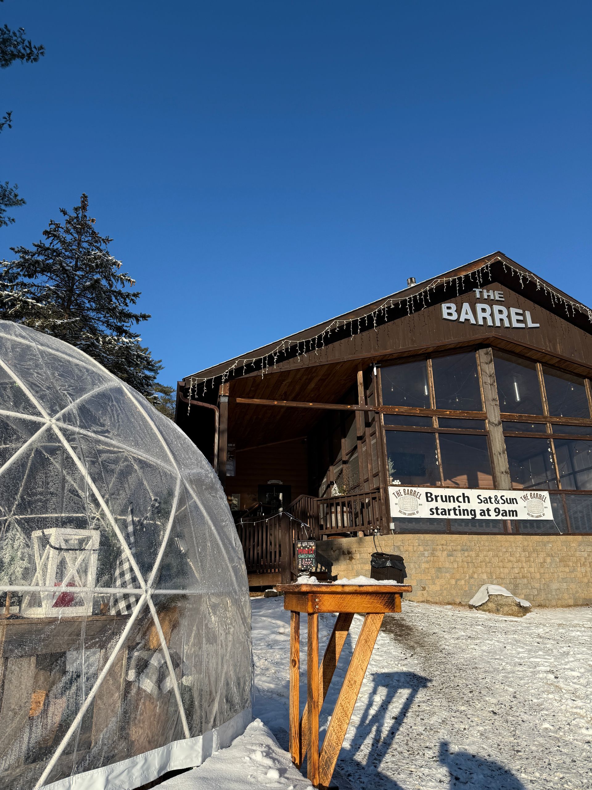 A dome is sitting in front of a building in the snow.