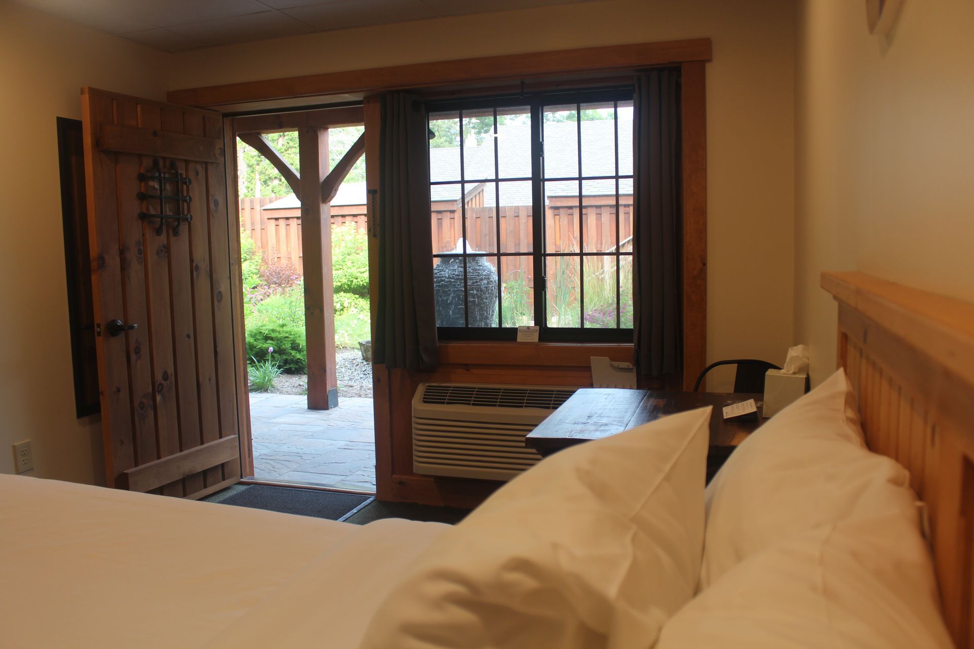 A hotel room with a king size bed and a large window.