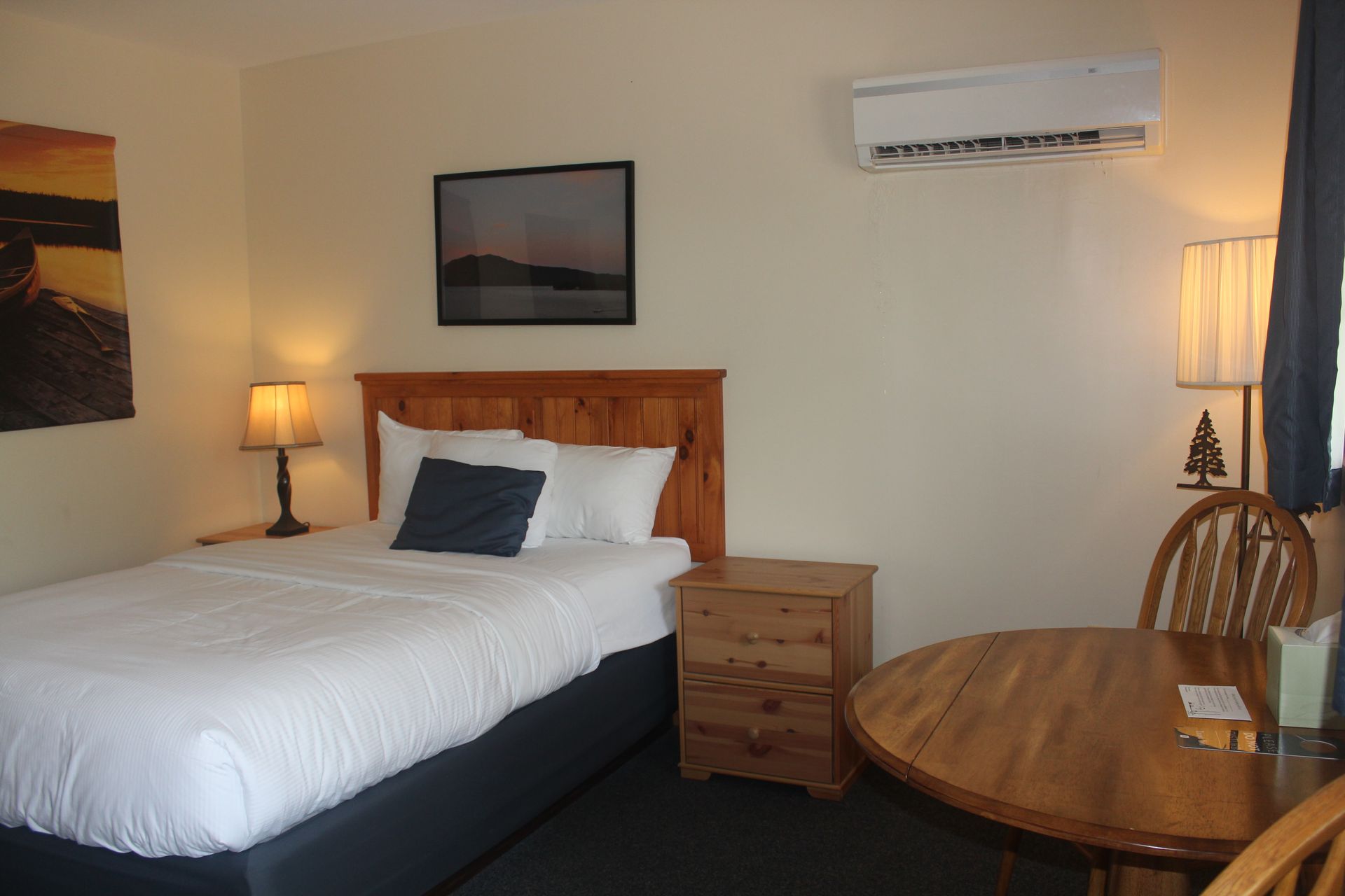 A hotel room with a bed , table and chairs