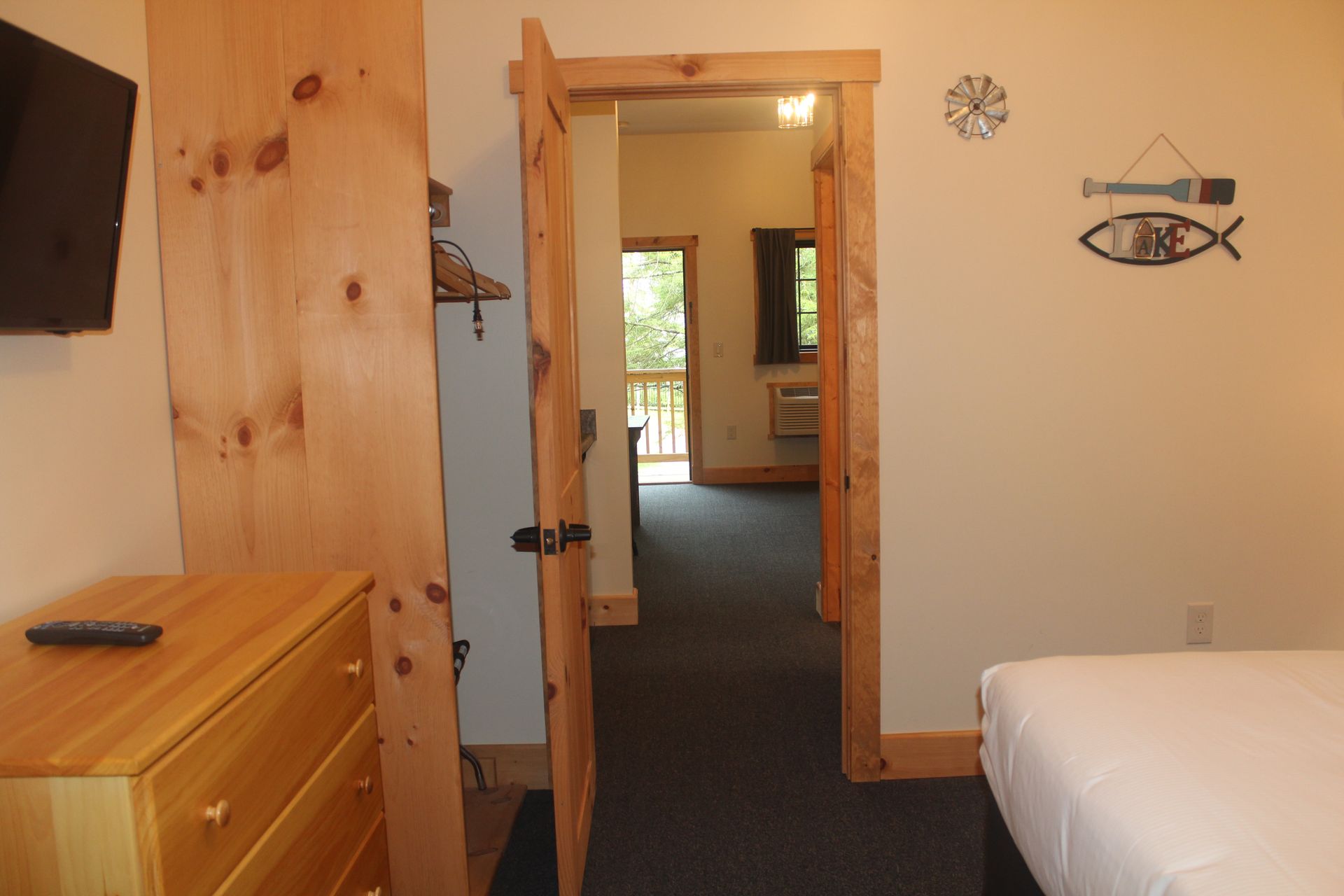 A bedroom with a bed , dresser and television.