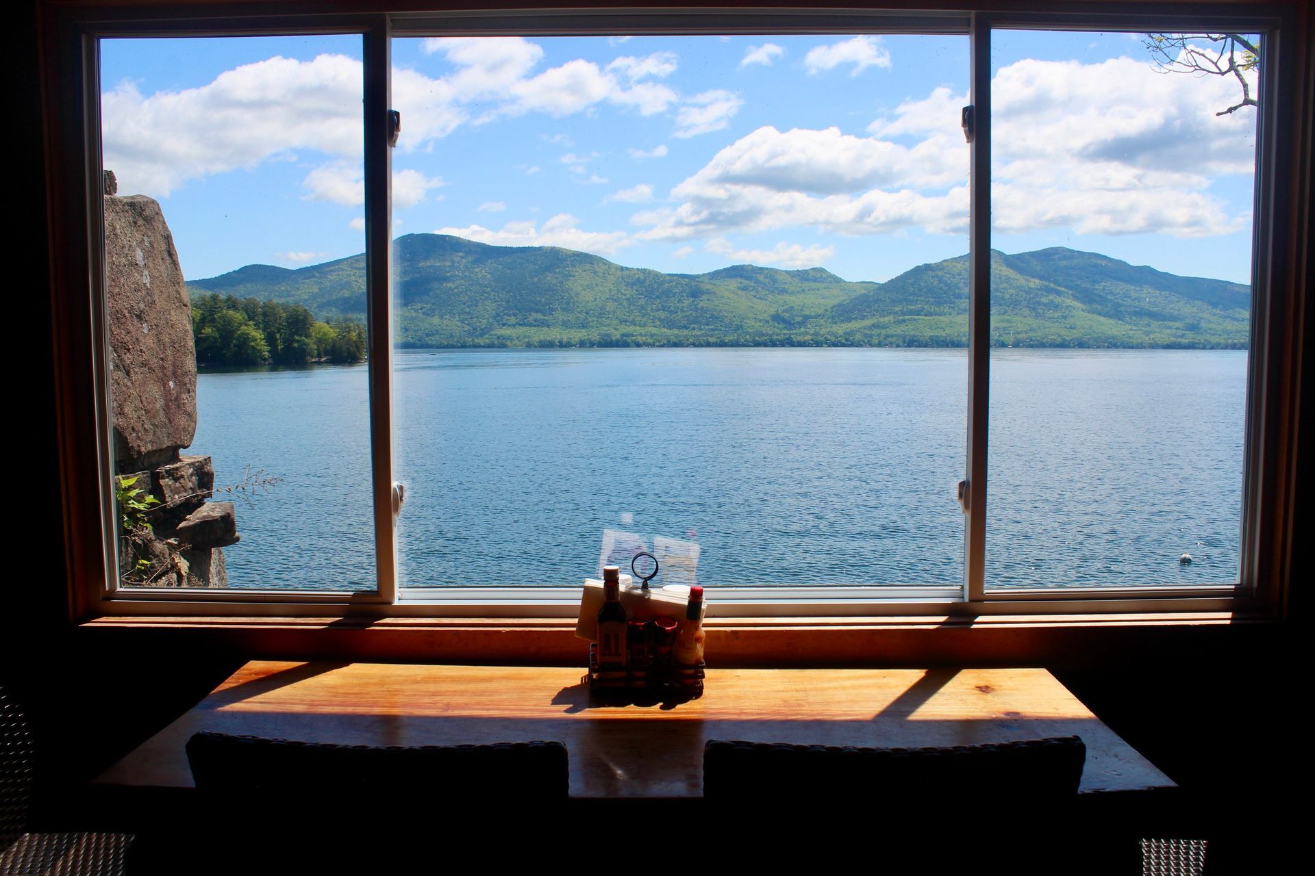 A view of a lake through a window with mountains in the background.