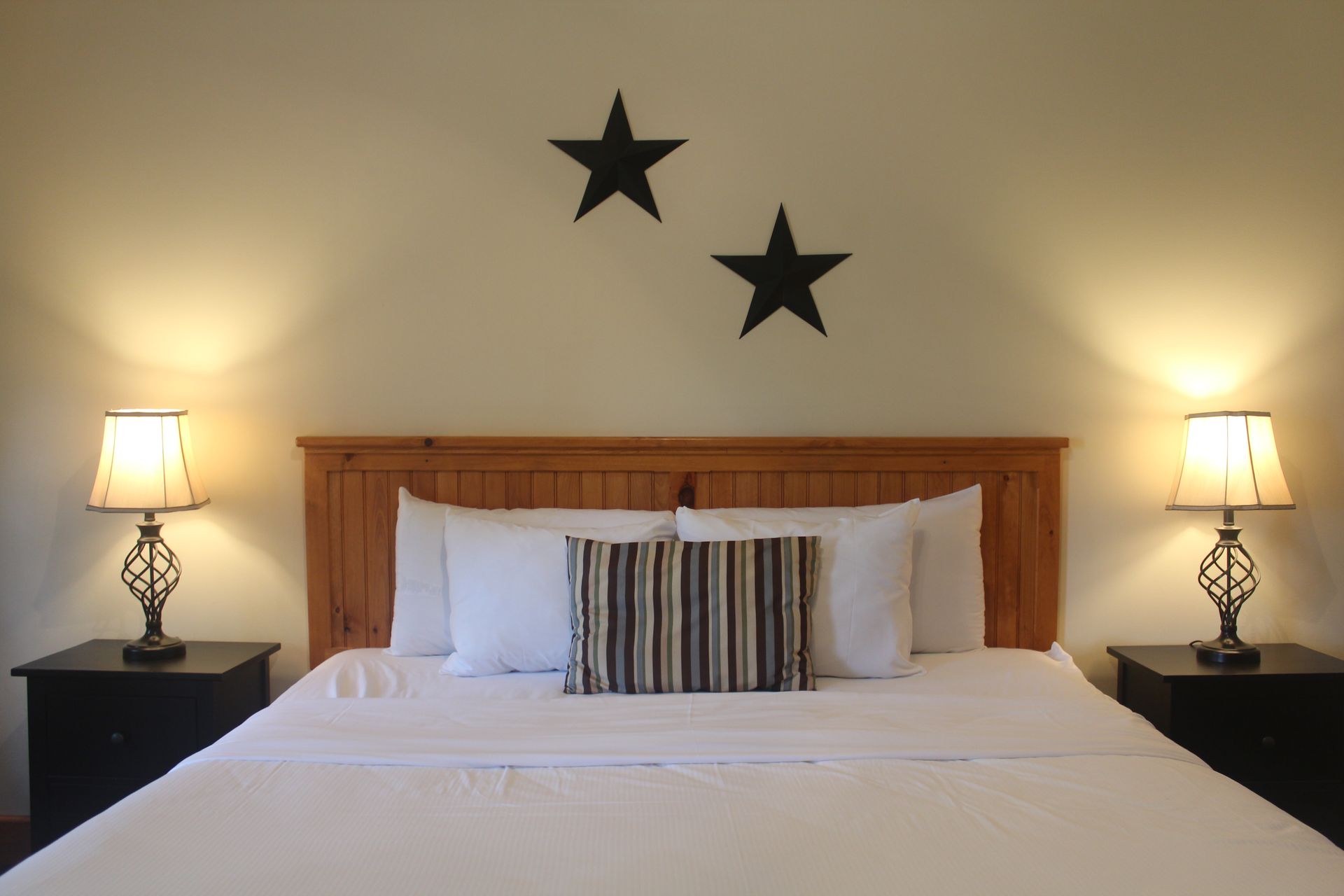 A bed with two black stars on the wall above it