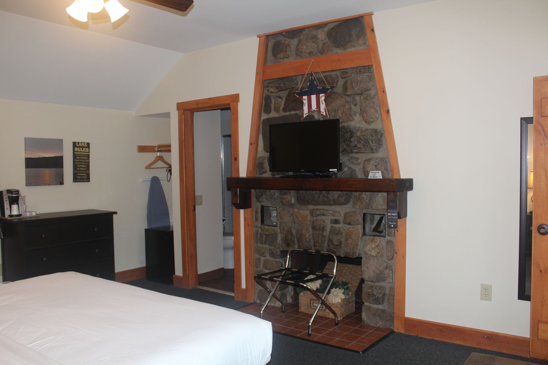A bedroom with a fireplace and a flat screen tv