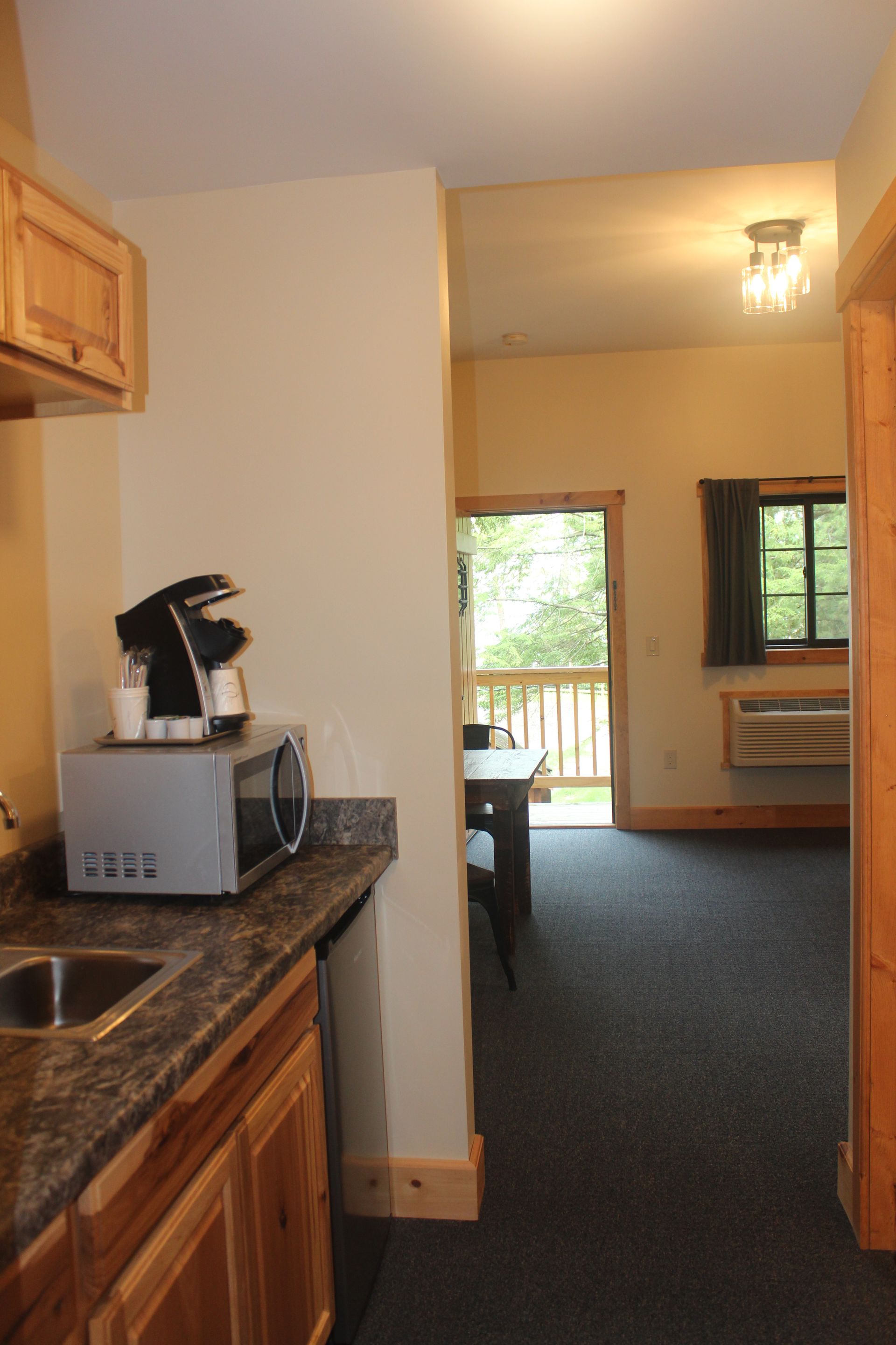 A kitchen with a sink , microwave and coffee maker
