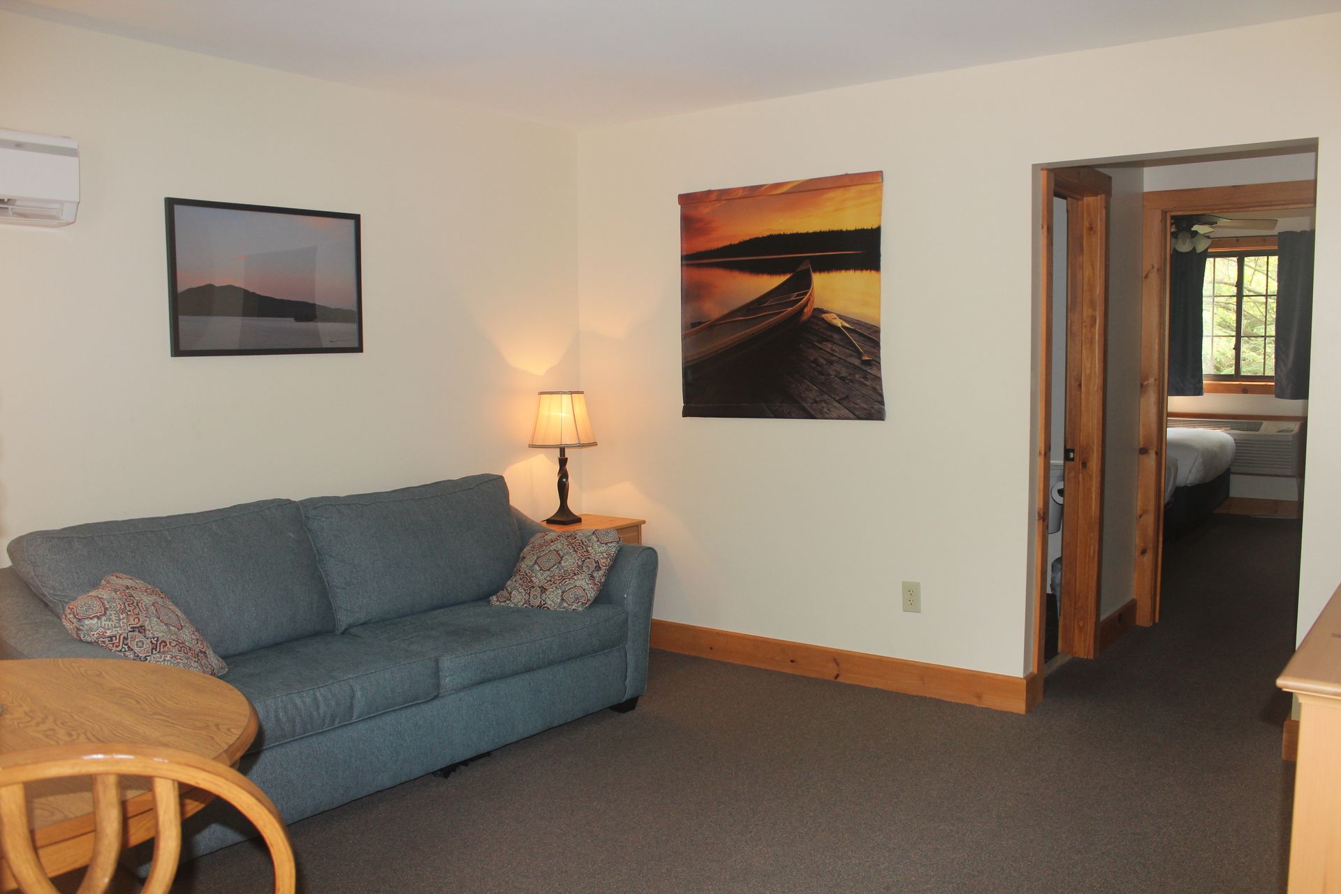 A living room with a blue couch and a picture on the wall