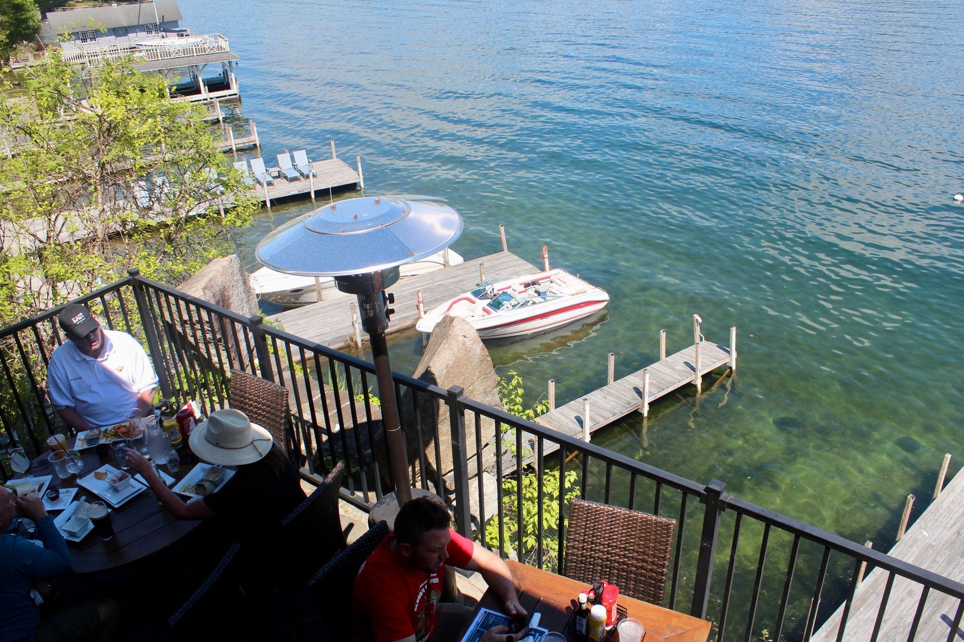 A group of people are sitting at a table overlooking a body of water.