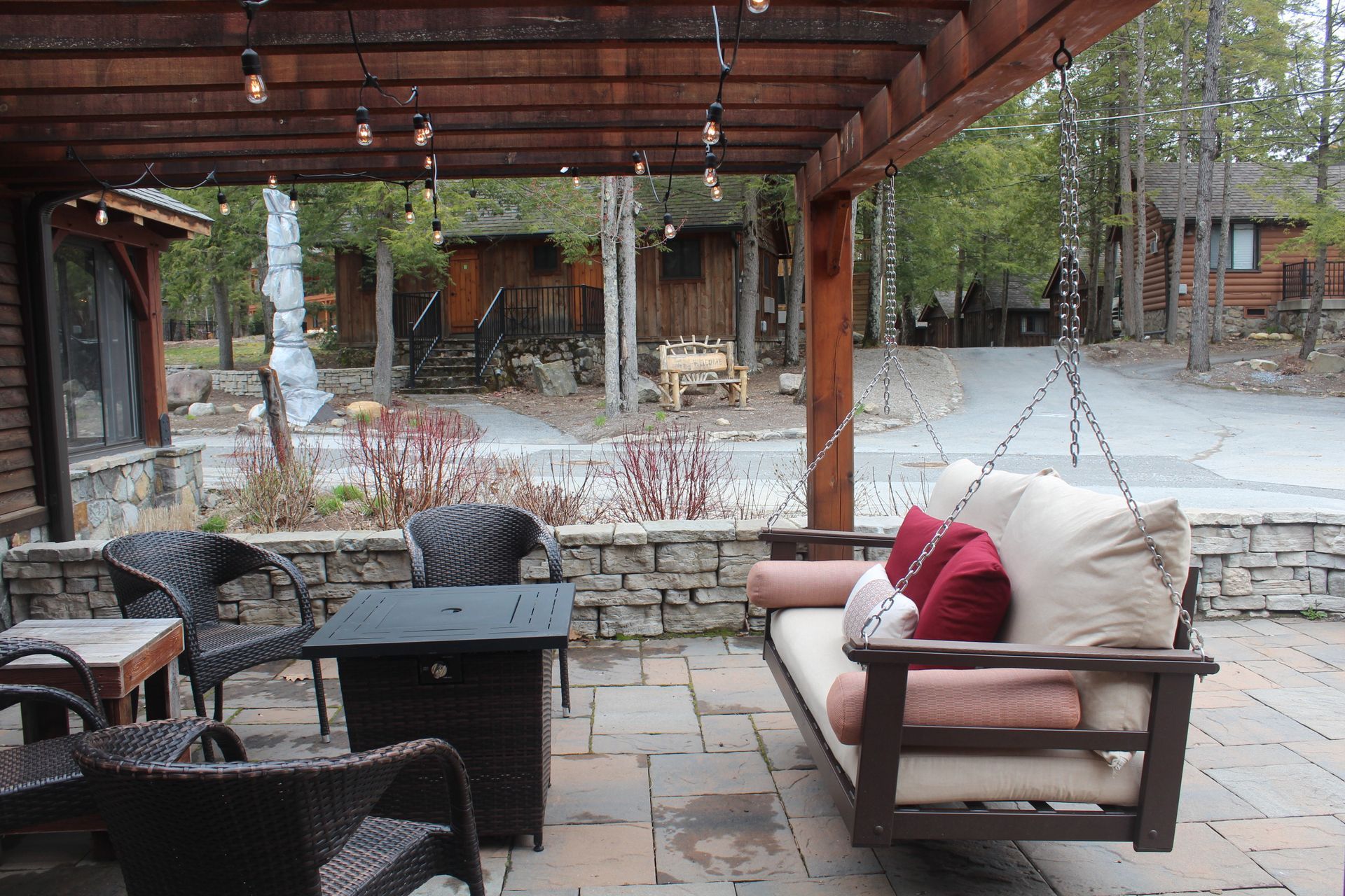 A patio with a couch and chairs under a pergola