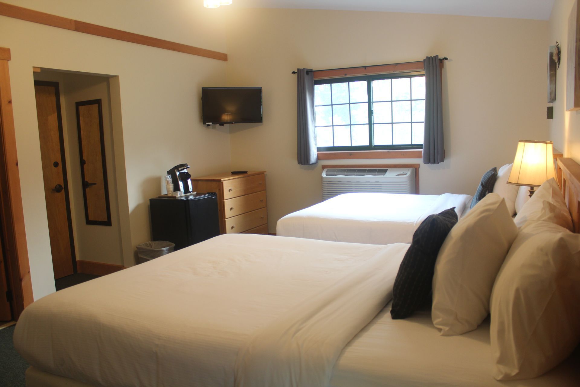 A hotel room with two beds and a window