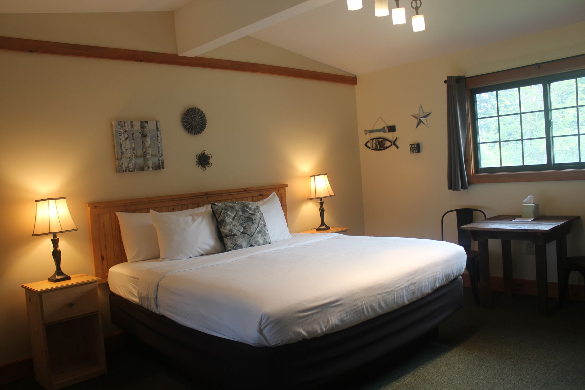 A hotel room with a king size bed and two lamps