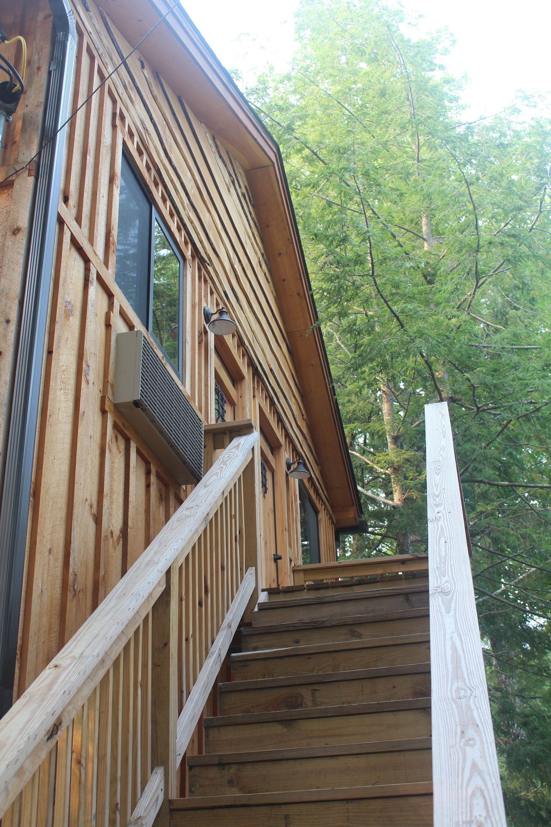 A wooden house with stairs leading up to it