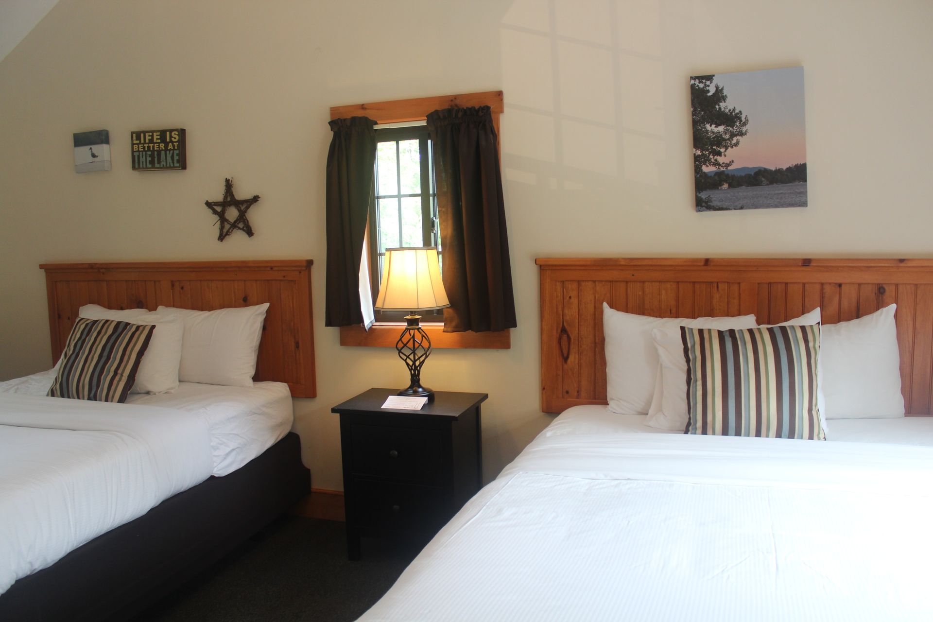 A hotel room with two beds and a nightstand