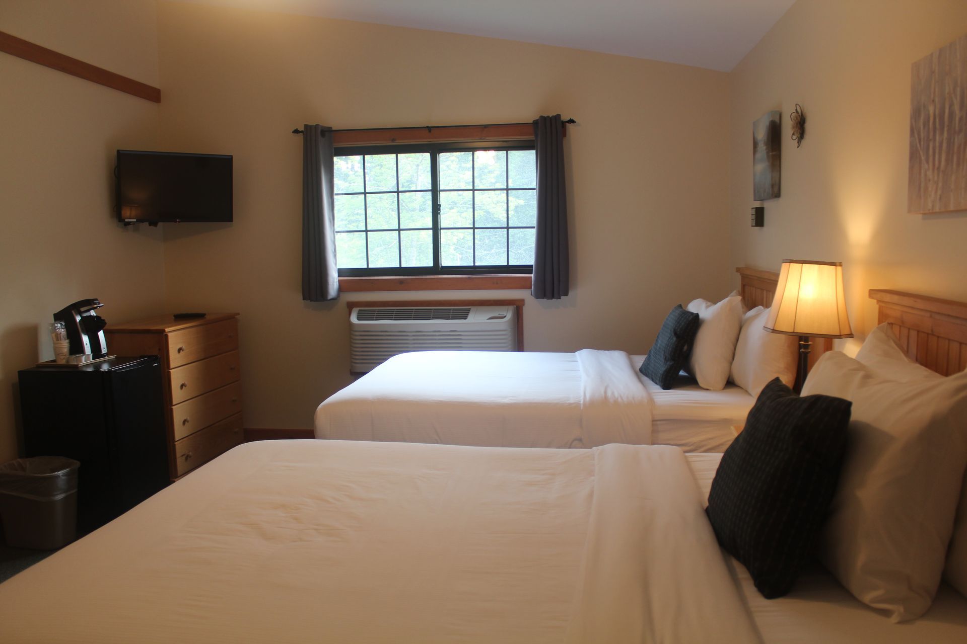 A hotel room with two beds and a television
