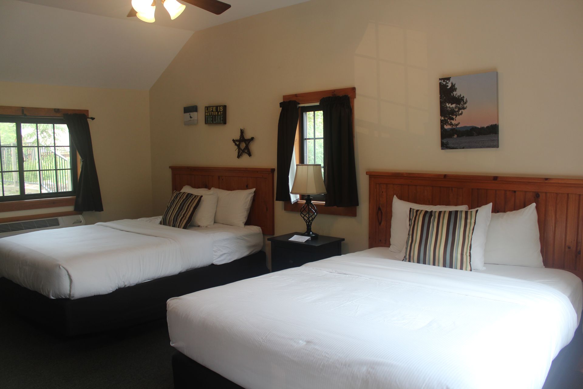 A hotel room with two beds and a lamp