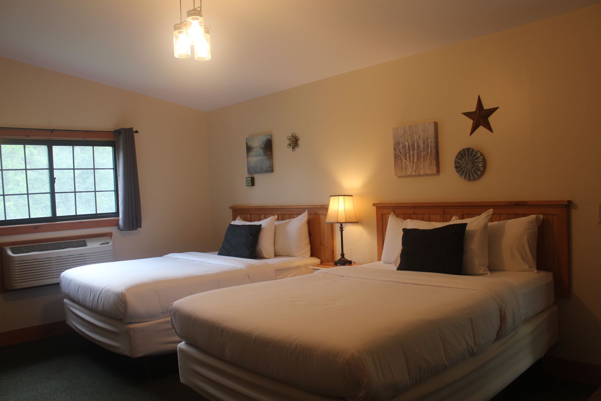 A hotel room with two beds and a window