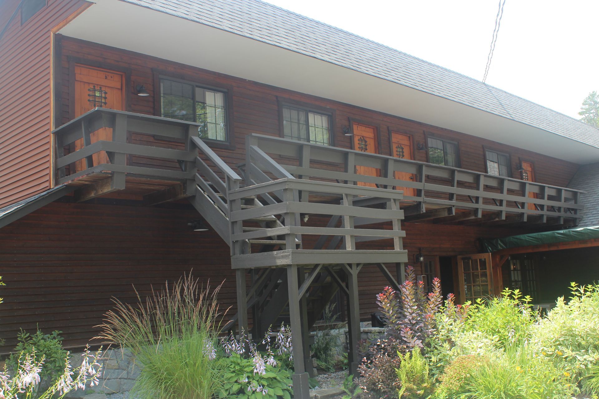 A large wooden building with stairs leading up to a balcony.
