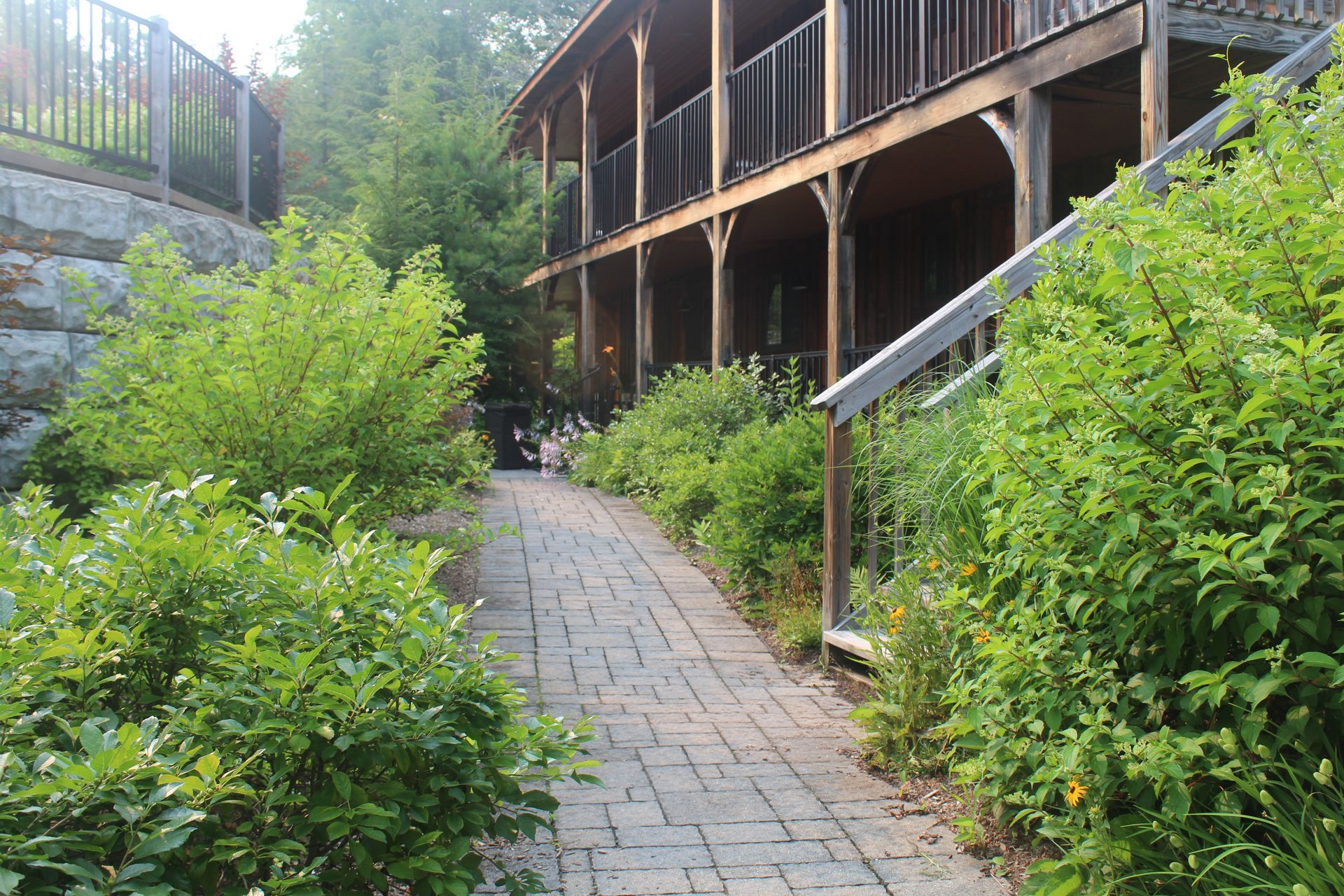 A brick walkway leading to a house with a porch
