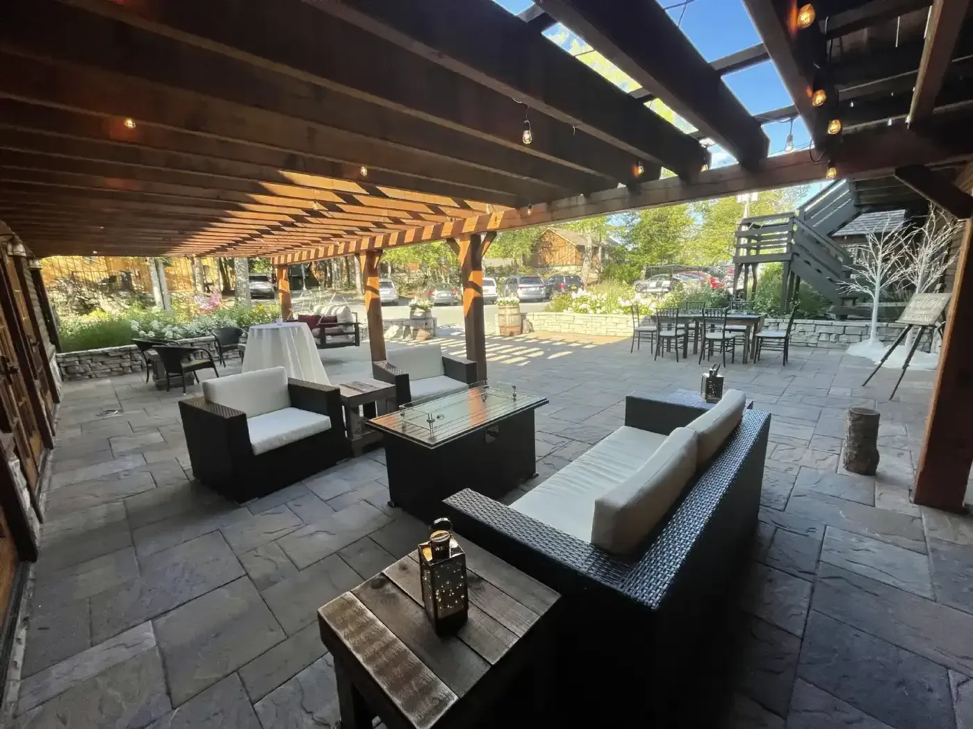 A patio with a lot of furniture under a pergola.